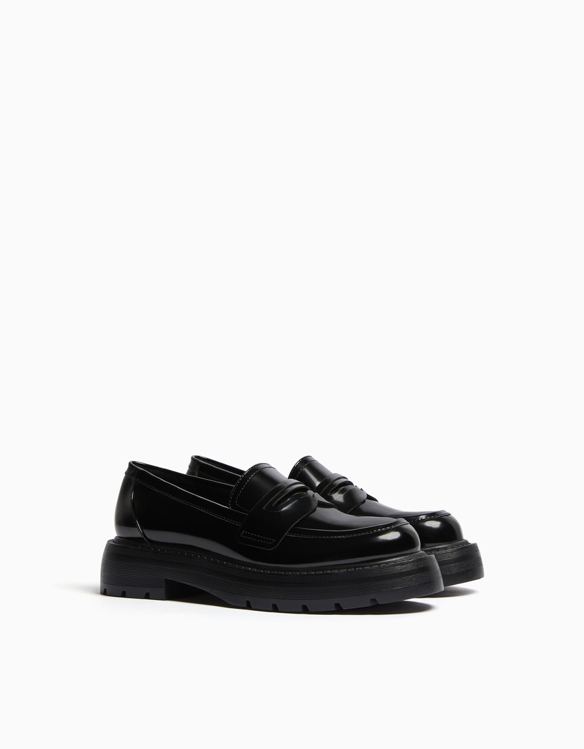 Mocassins com tira de metal e solado tratorado.