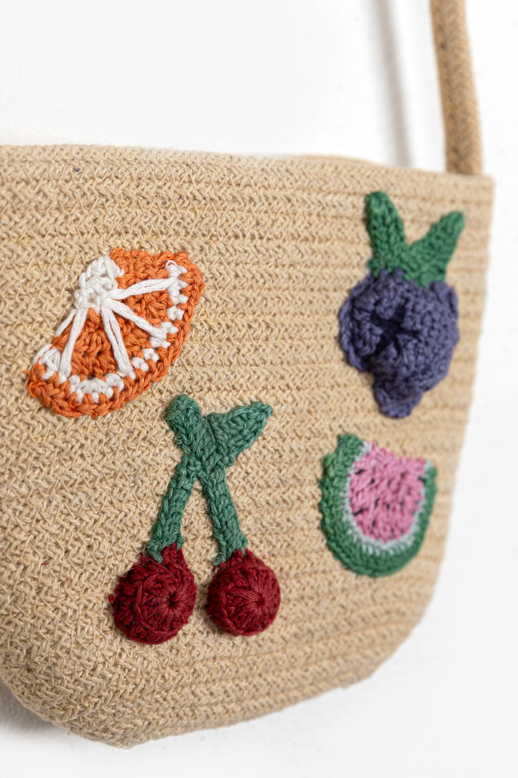 Crossbody tas van stro met gehaakte fruit emblemen