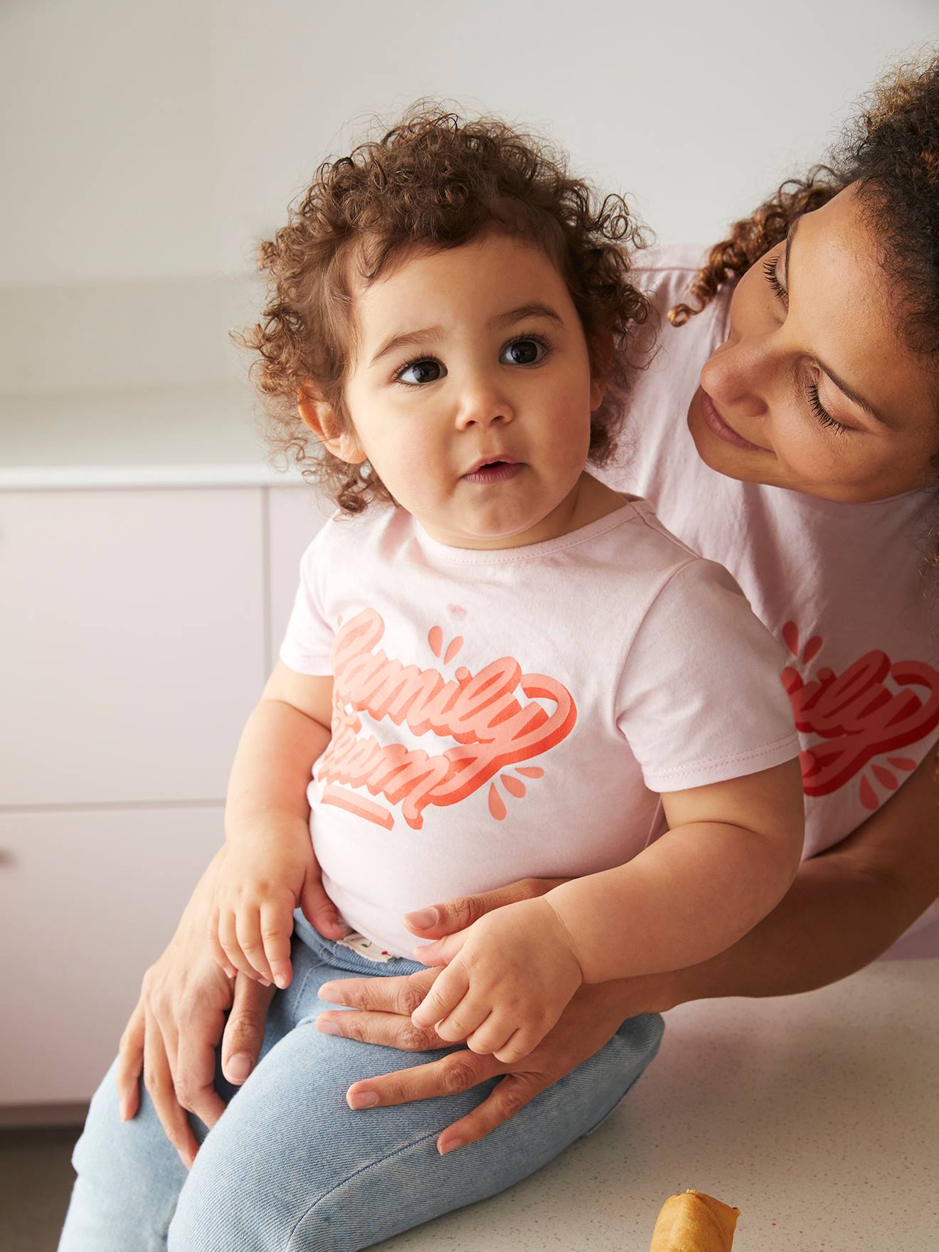 Camiseta infantil Family Team da coleção cápsula Vertbaudet e Studio Jonesie, feita de algodão orgânico rosa claro liso com estampas.