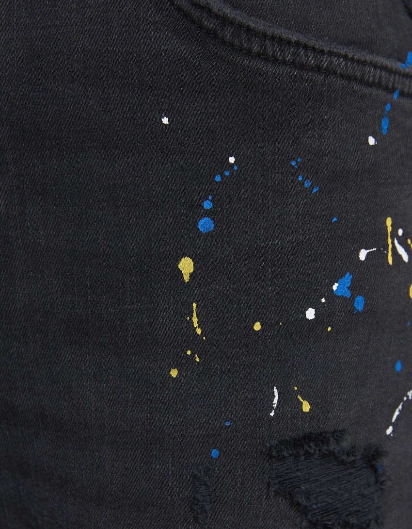 Calça jeans super skinny rasgada com respingos de tinta