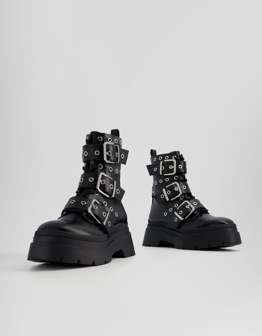 Botas de cano curto sem salto, com tiras, ilhós e fivelas.