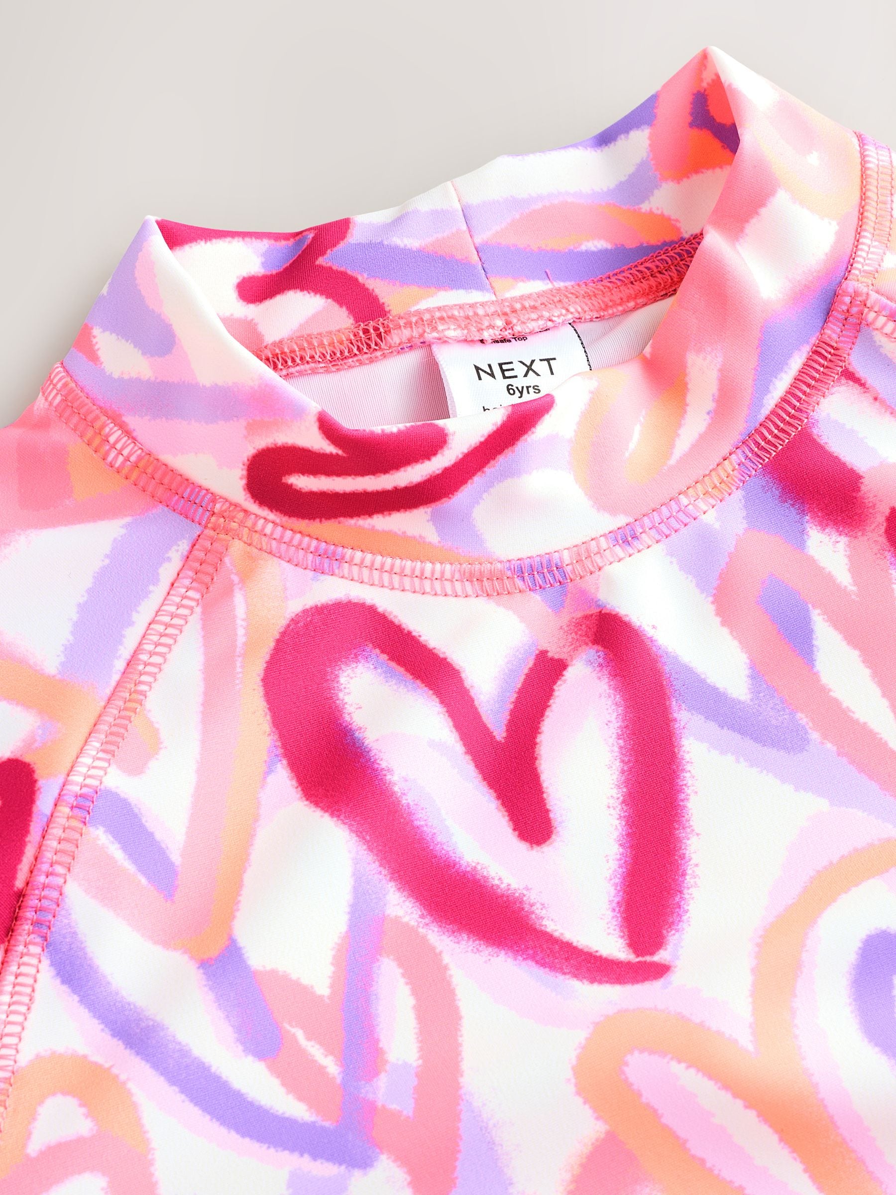 Roze met hartjesprint - Zonbeschermende set van surfshirt en shorts (3 - 16 jr)
