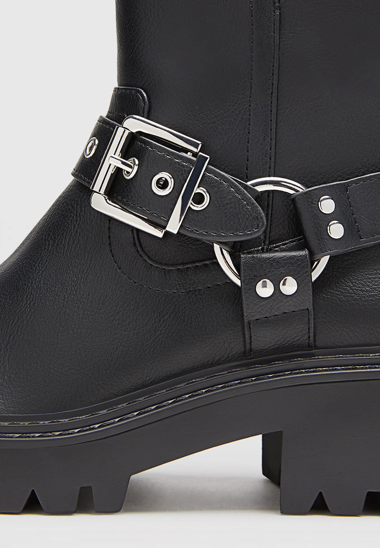 Botas de cano curto estilo motociclista, sem salto, com detalhes de fivela.