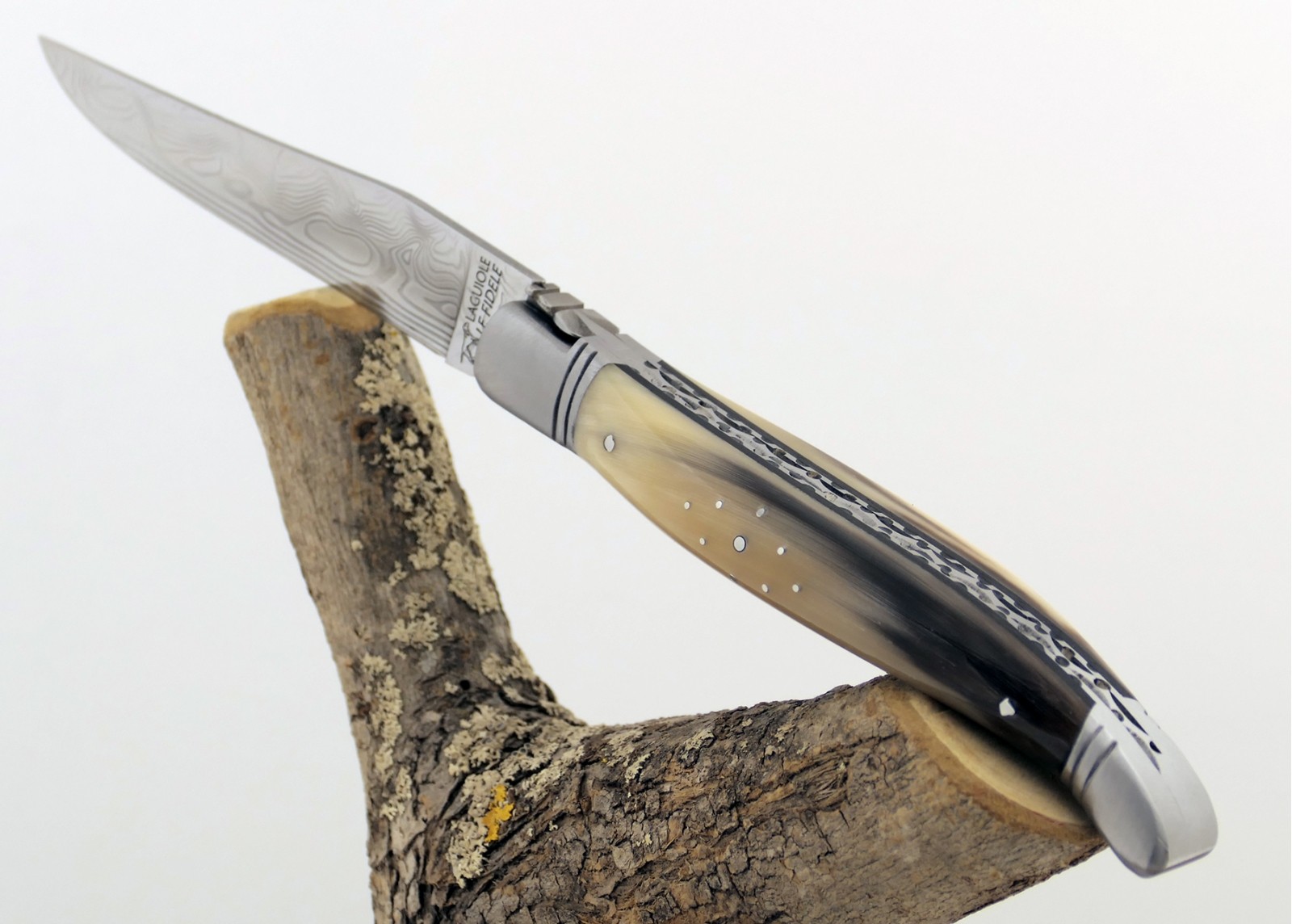 Couteau Laguiole prestige avec un manche en pointe de corne blonde et mitres en acier inoxydable et lame Damas