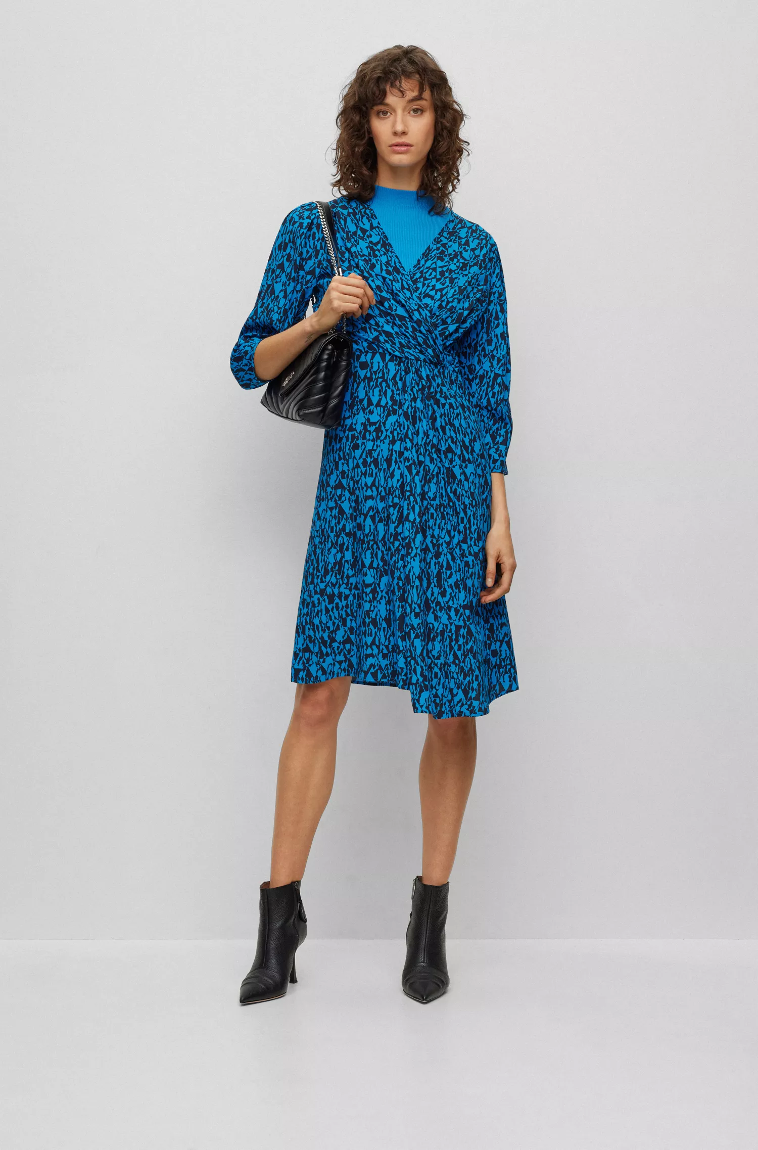 Vestido preto BOSS com decote em V e amarração frontal, com estampa da estação.