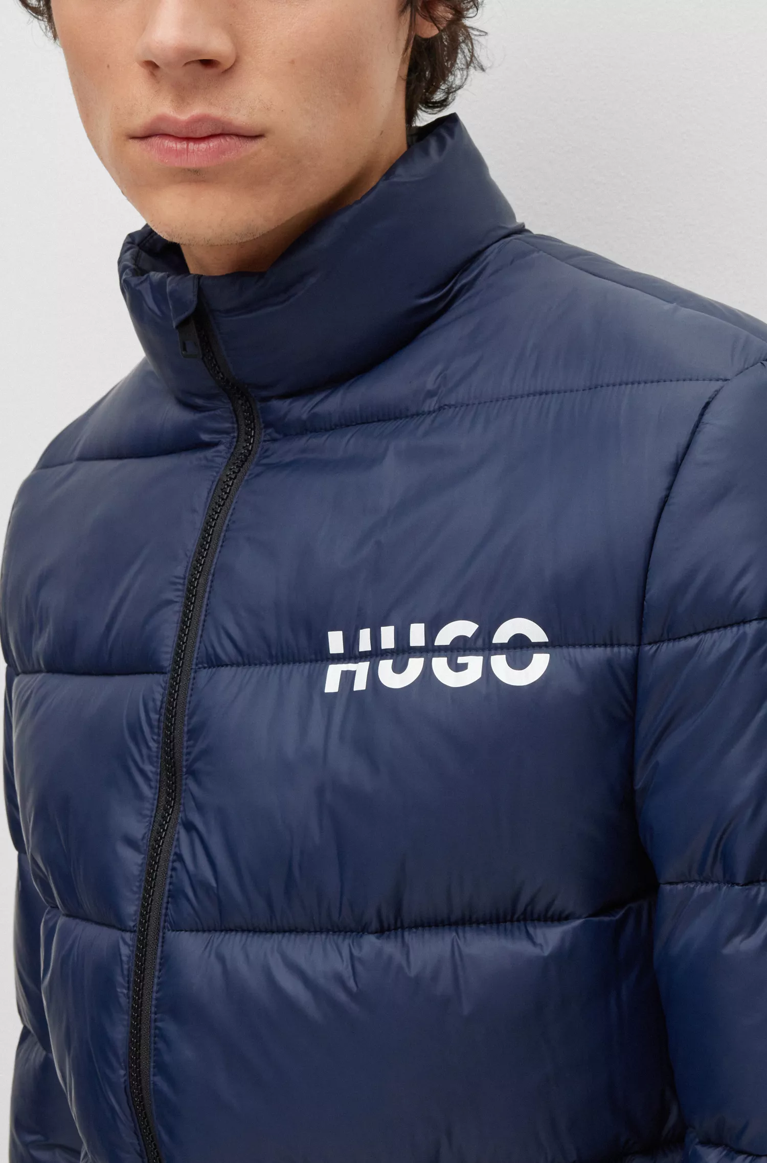 Jaqueta puffer HUGO vermelha, corte slim, com logo dividido.