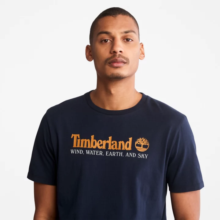 Camiseta masculina azul marinho com estampa de vento, água, terra e céu.