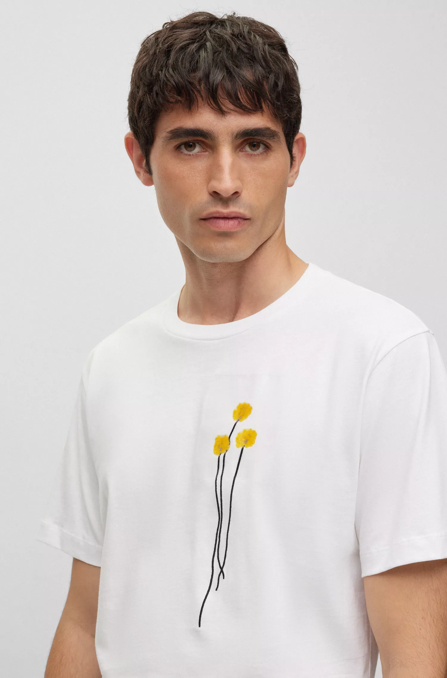 Camiseta BOSS preta em algodão interlock com pétalas de flores artificiais.