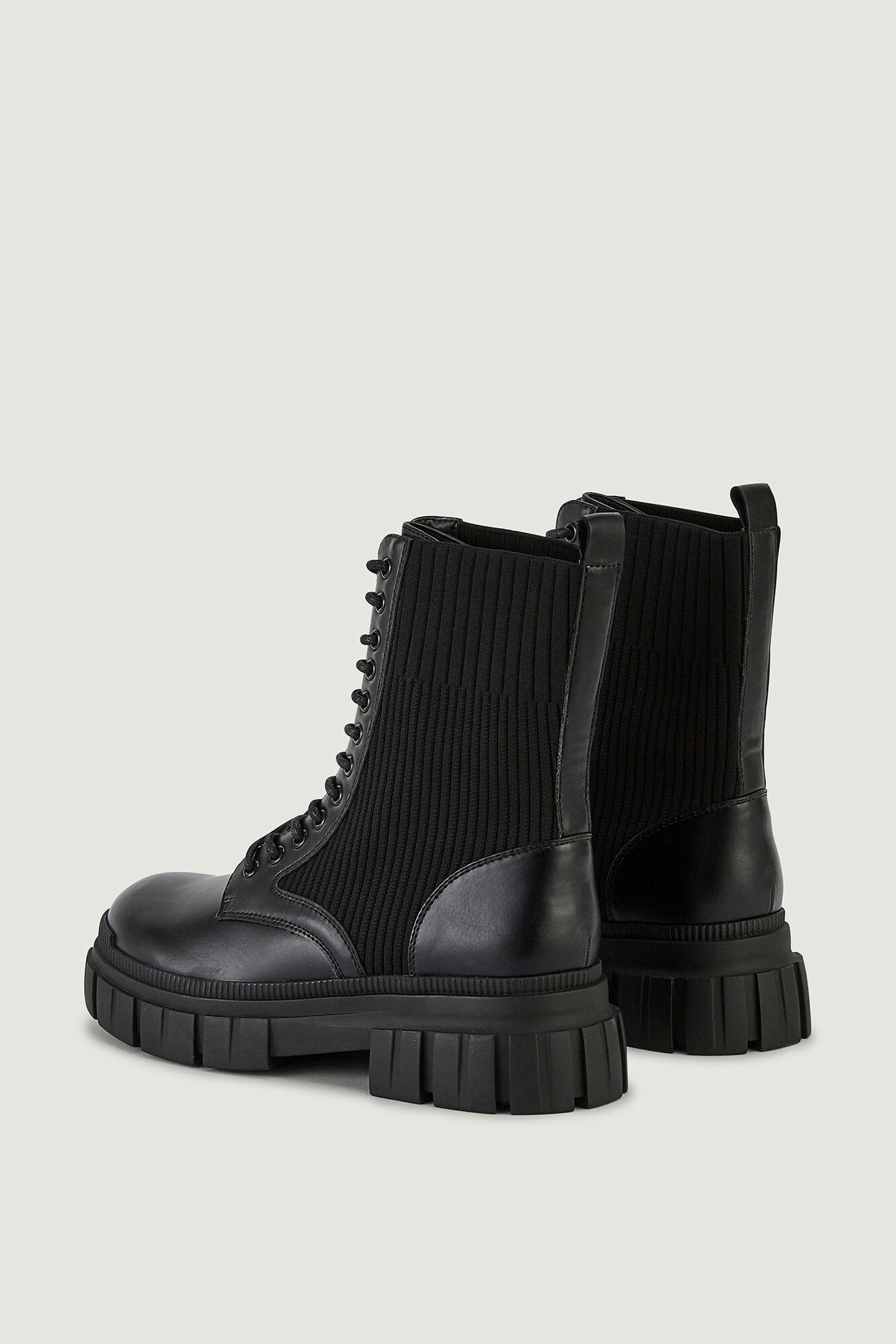 Botas de cano curto em imitação de couro com cadarços e sola serrilhada.