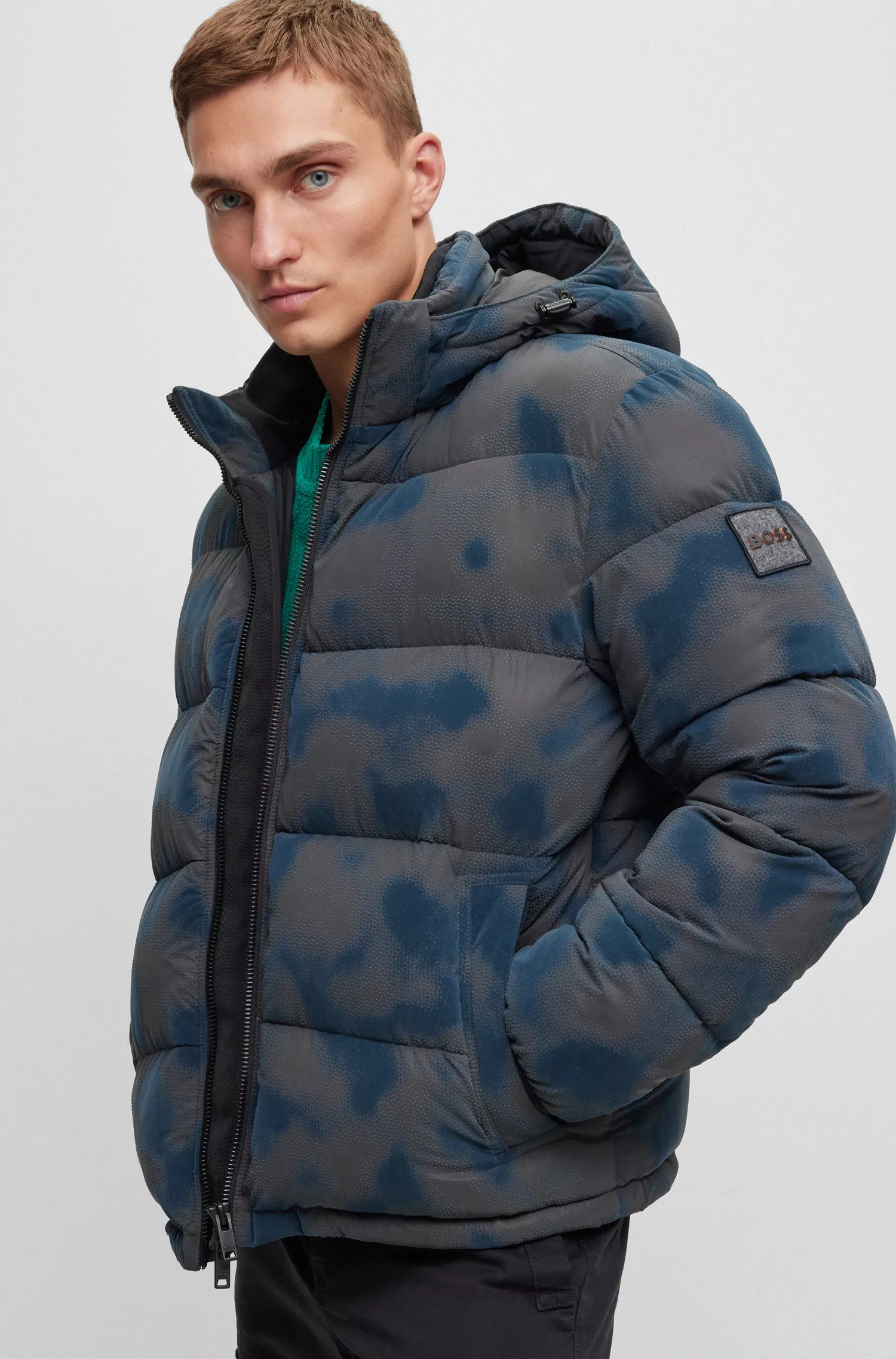 Jaqueta puffer BOSS laranja, modelagem relaxada e estampa flocada da estação.