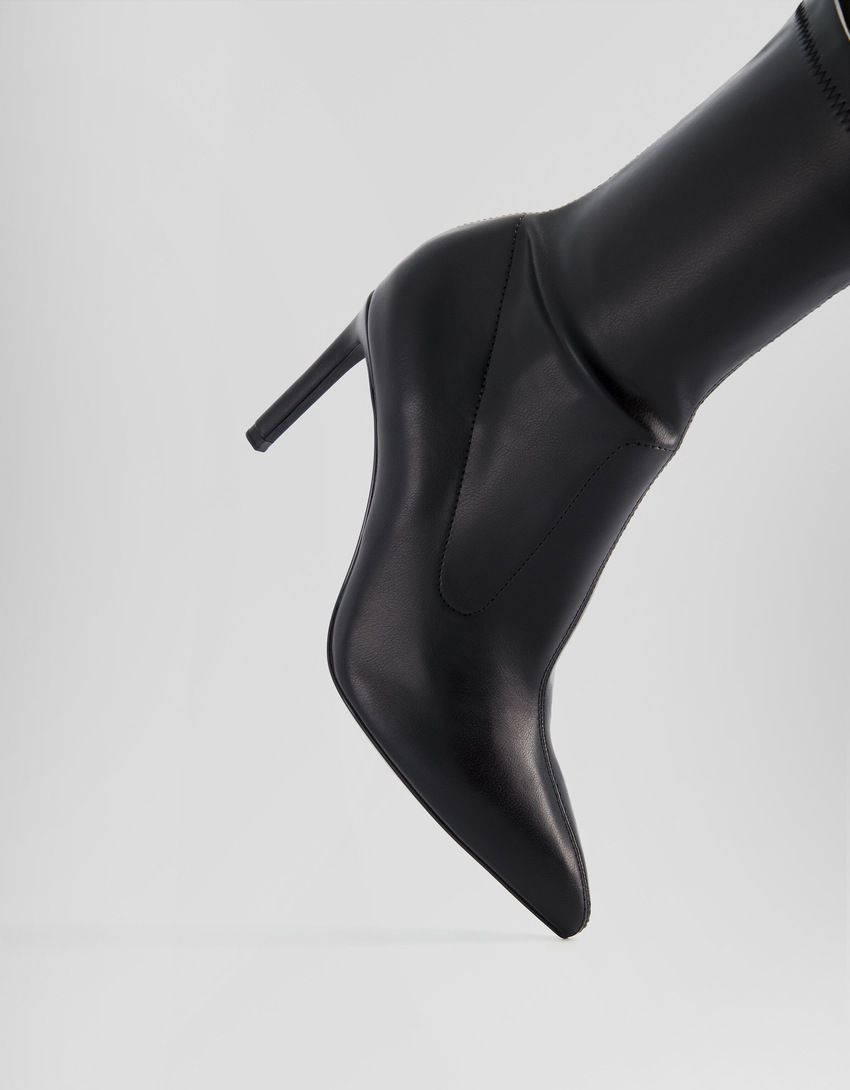 Botas de cano curto com salto alto e modelagem ajustada