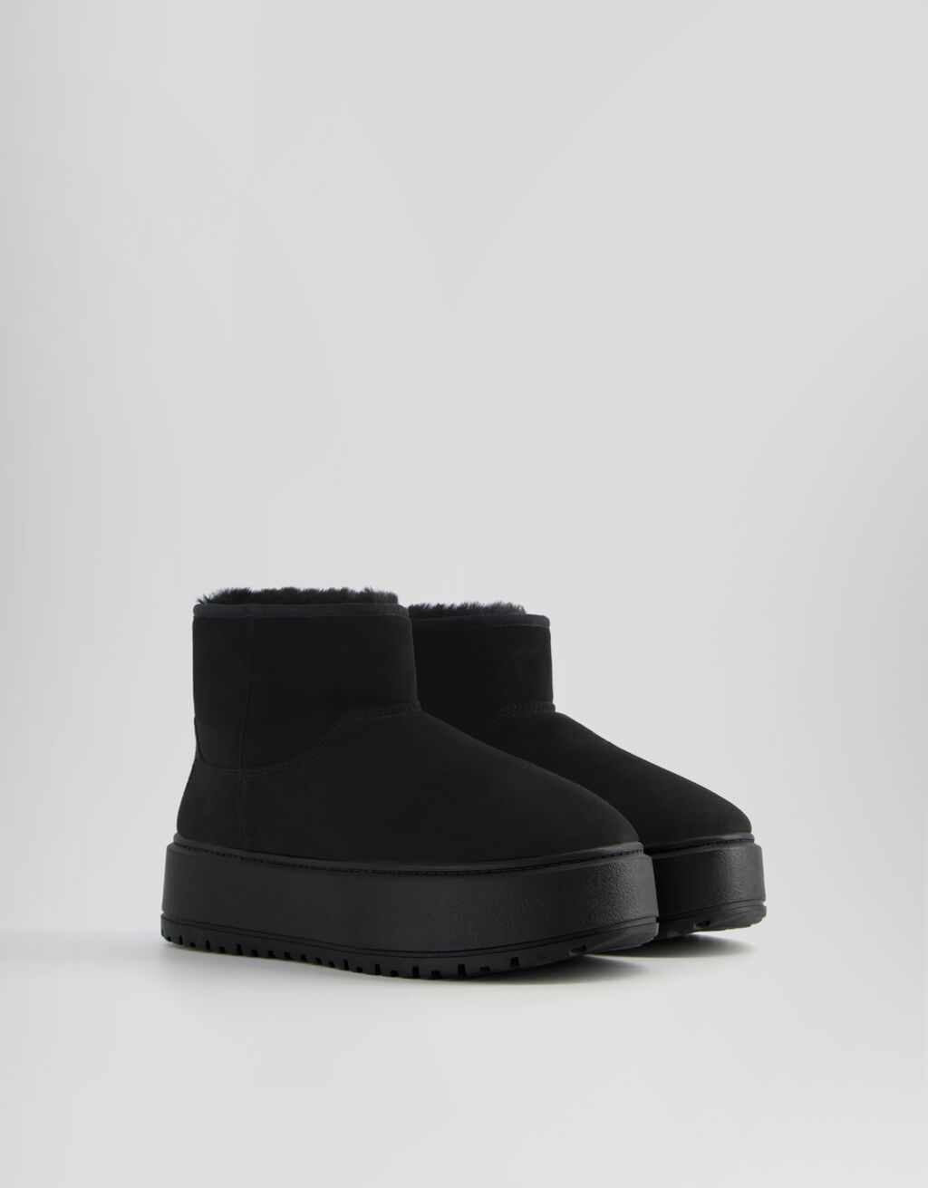 Botas de cano curto com plataforma e forro de pele sintética.