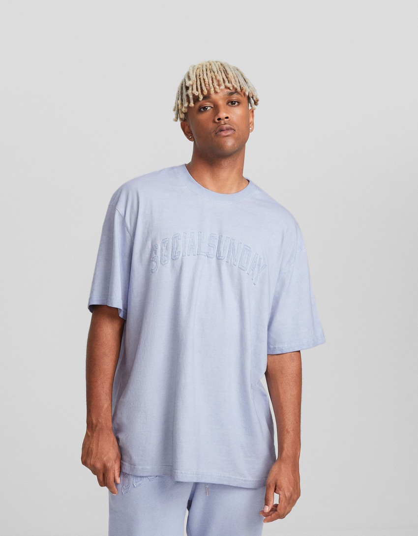 Camiseta de manga curta com modelagem quadrada e detalhes em patch.