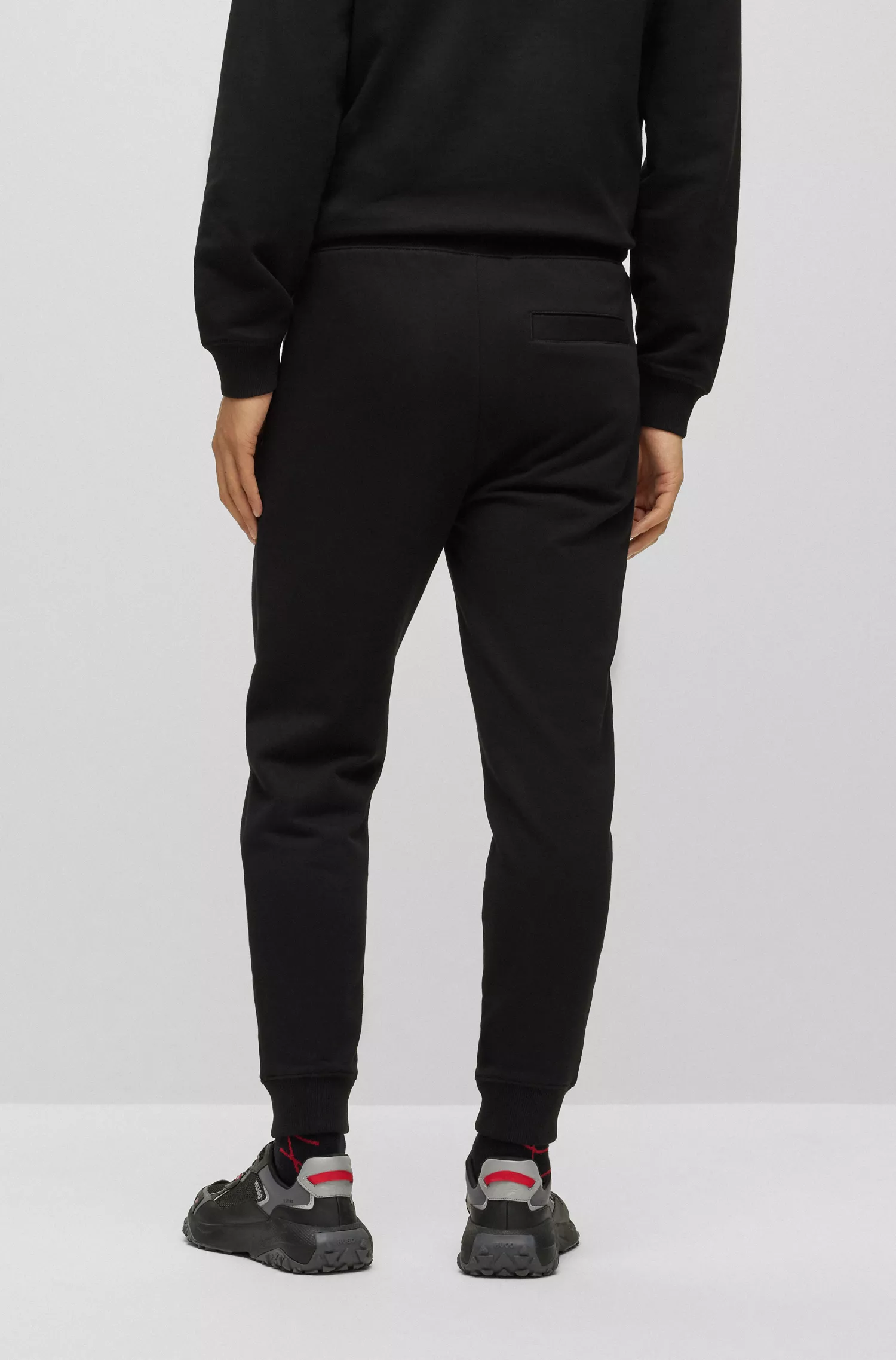 Calça de fato de treino HUGO em tecido atoalhado de algodão vermelho com logótipo de efeito metálico.