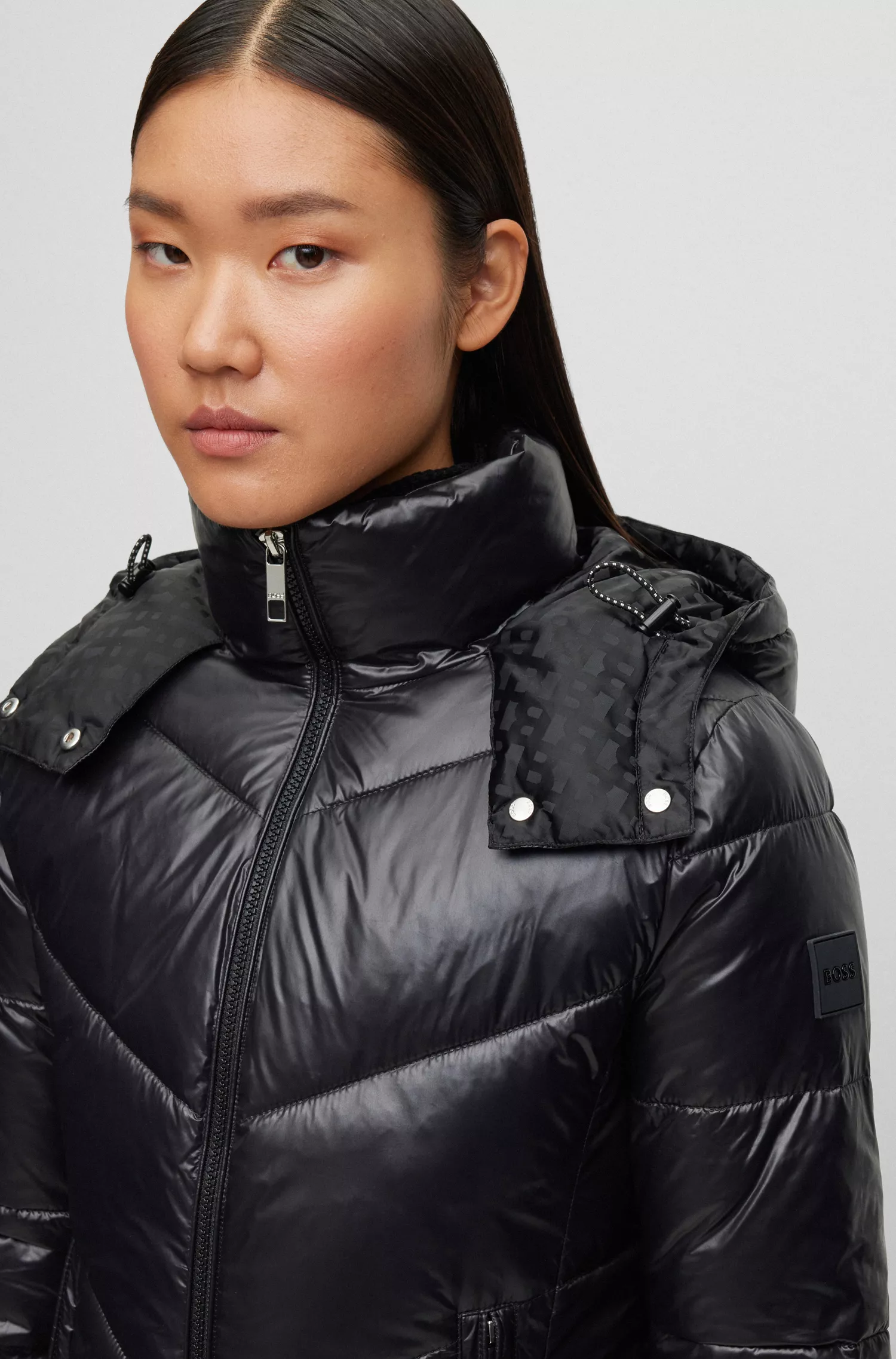 Jaqueta puffer BOSS preta, repelente à água e com acabamento brilhante.