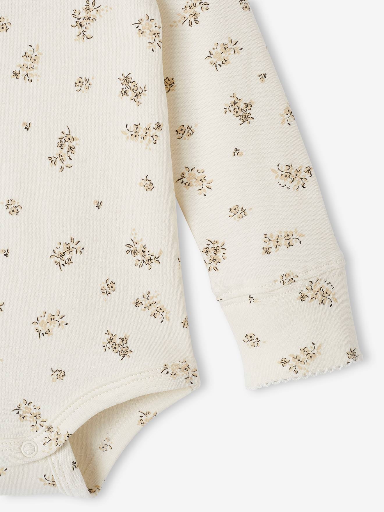 Body de bebê em tons naturais com estampa floral e gola Peter Pan.