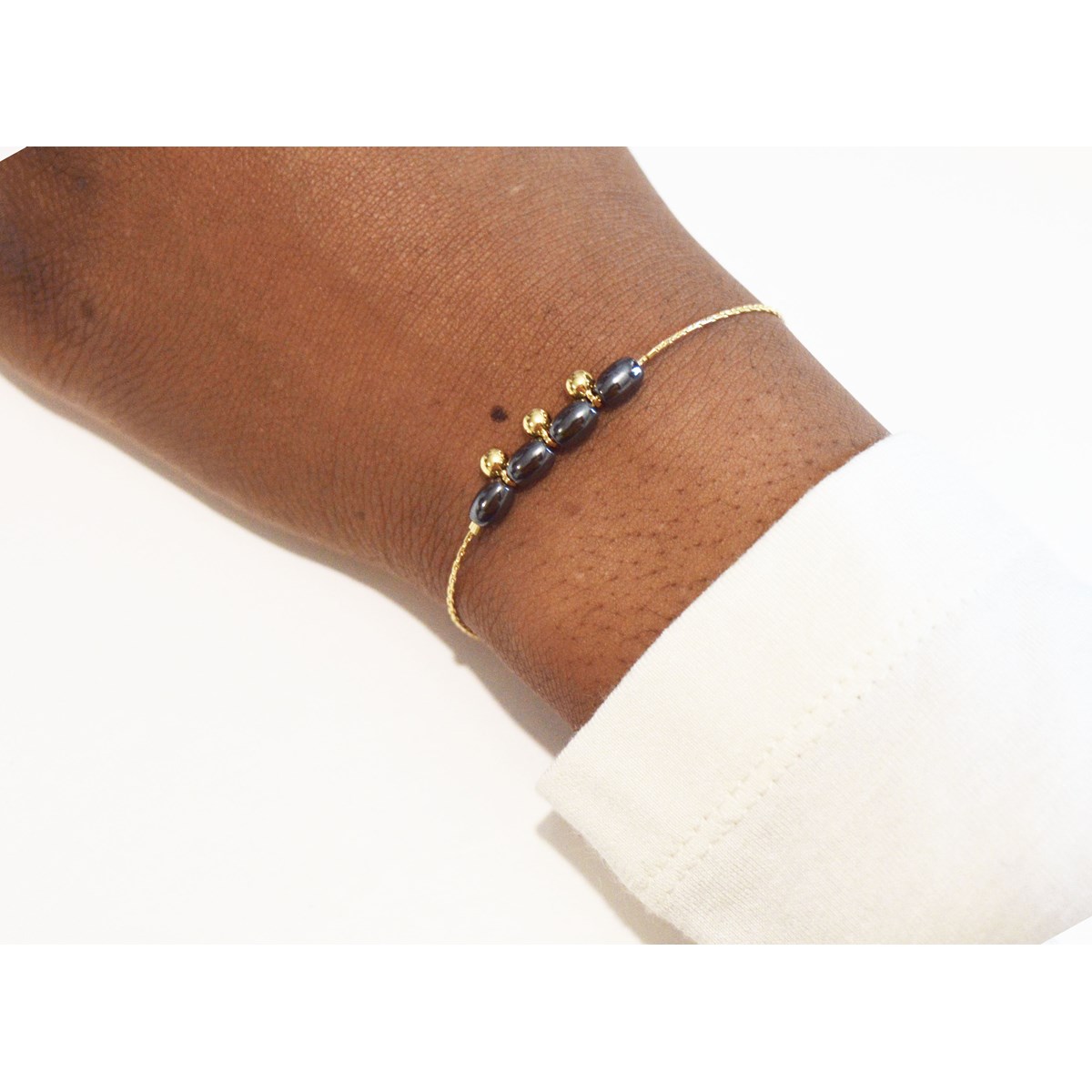 Bracelet orné de perles d ' hématite et breloques dorées