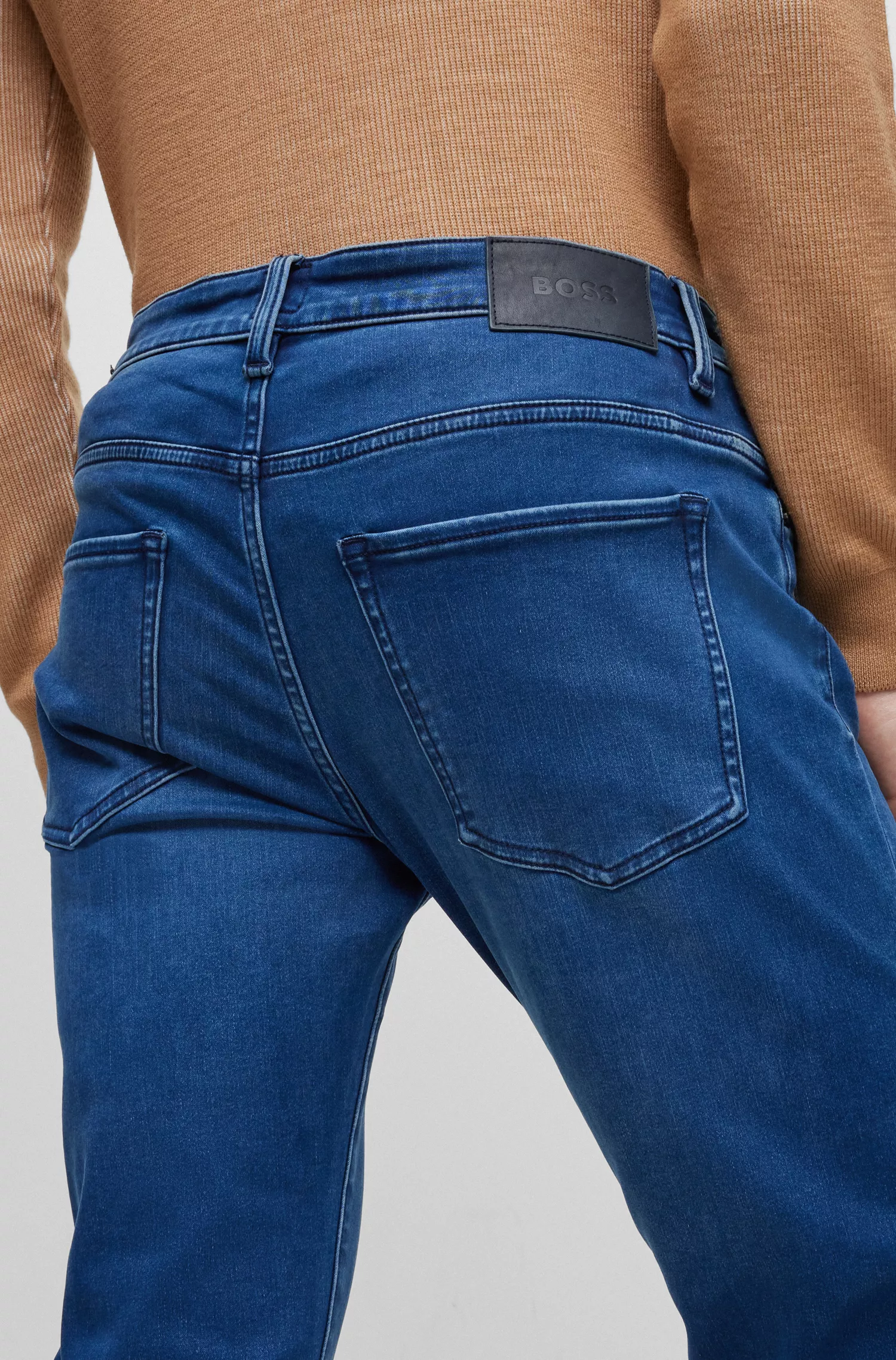 Calça jeans BOSS preta, corte slim, em denim elástico azul.