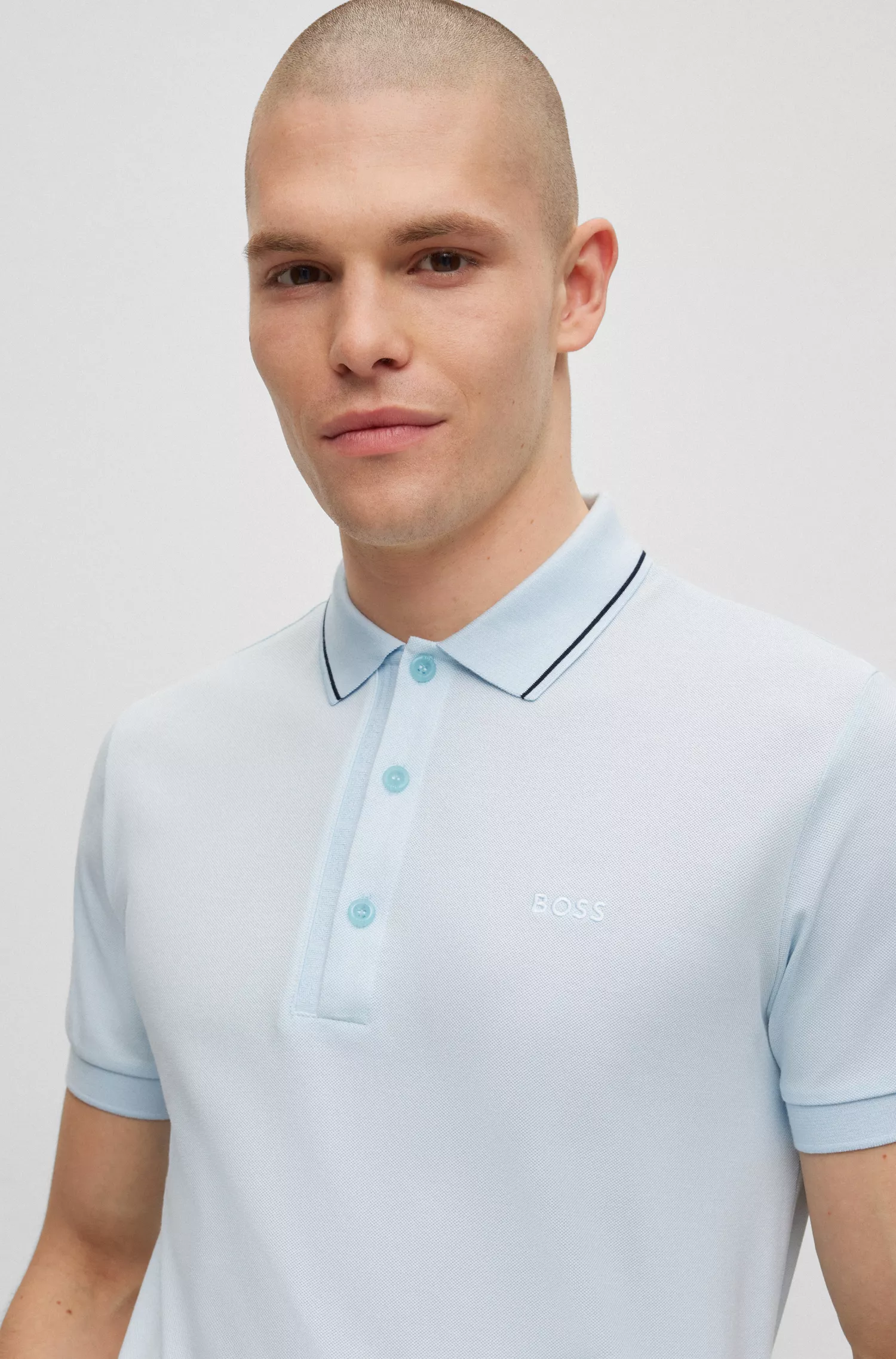 Camisa polo BOSS verde, corte slim, com detalhe da marca na gola.