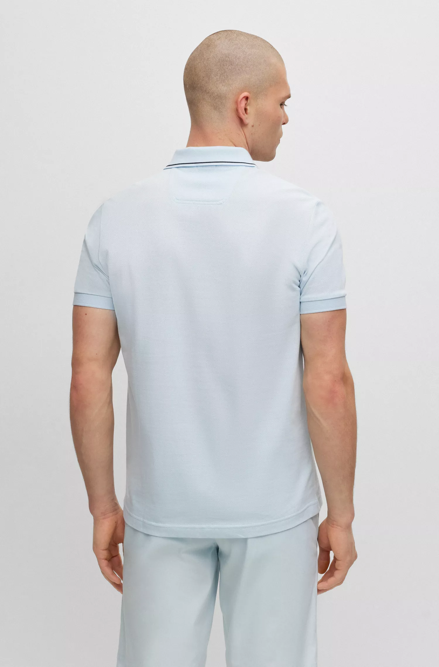 Camisa polo BOSS verde, corte slim, com detalhe da marca na gola.