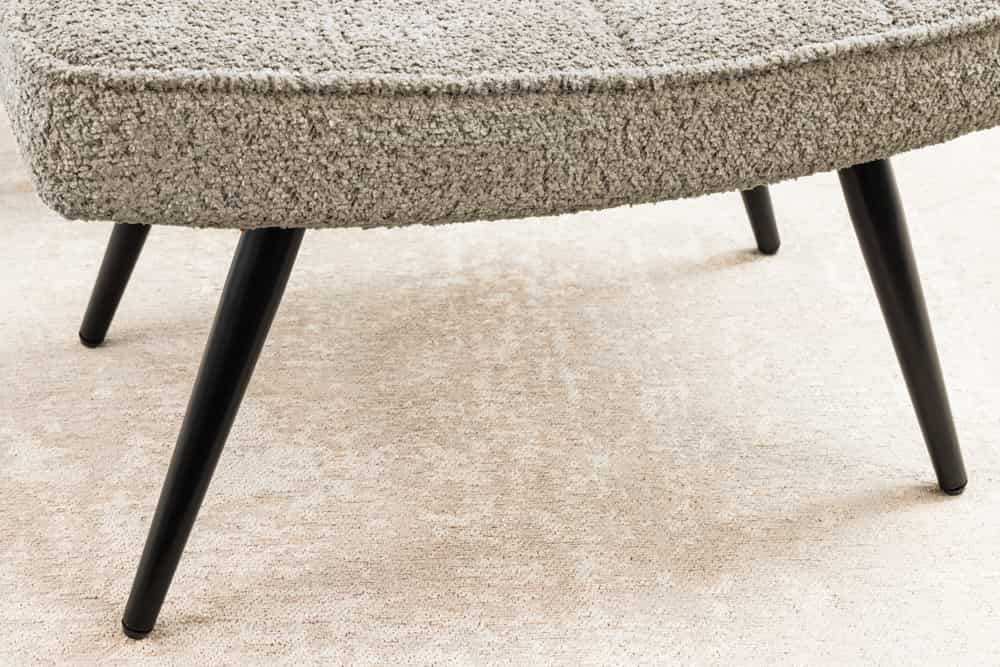 Moderner Hocker SCANDINAVIA champagner greige Bouclé schwarze Metallbeine Fußhocker