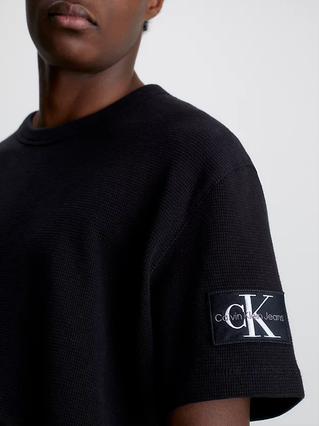 Camiseta de algodão com textura alveolar e modelagem slim, com brasão.
