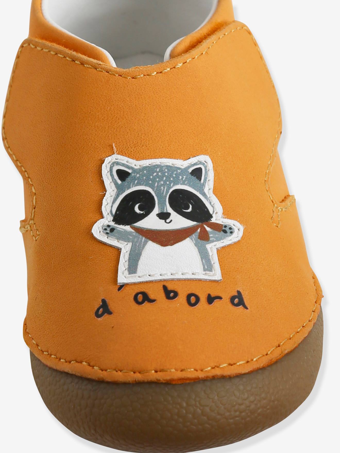 Pantufas amarelas para bebê, feitas de couro flexível com fecho de velcro.