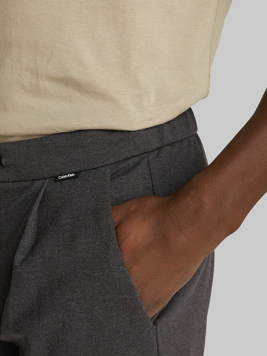 CALVIN KLEIN<br>Calças plissadas e afuniladas
