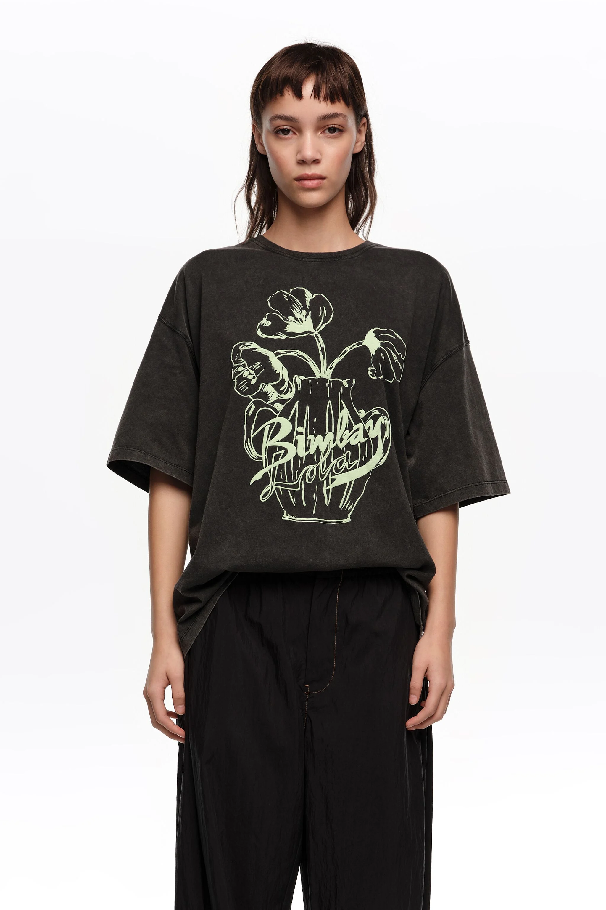 Camiseta preta desbotada com logo floral em relevo
