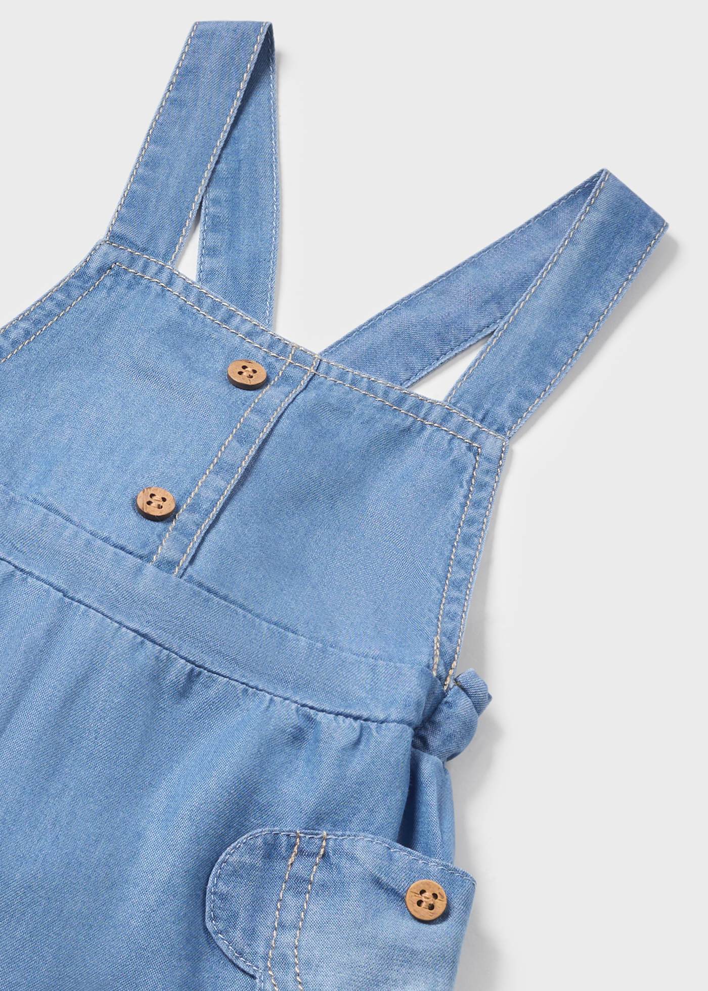 Conjunto de duas peças para recém-nascido: jardineira jeans e saia.