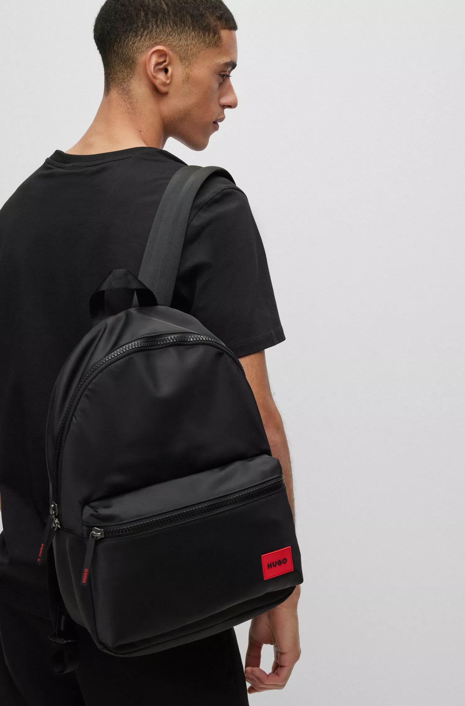 Mochila HUGO vermelha com etiqueta de borracha vermelha com o logotipo e alça superior.