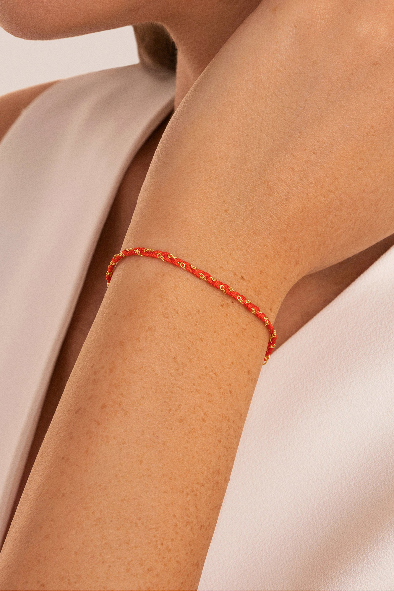 Pulseira de fio banhada a ouro e prata nas cores vermelho e branco.
