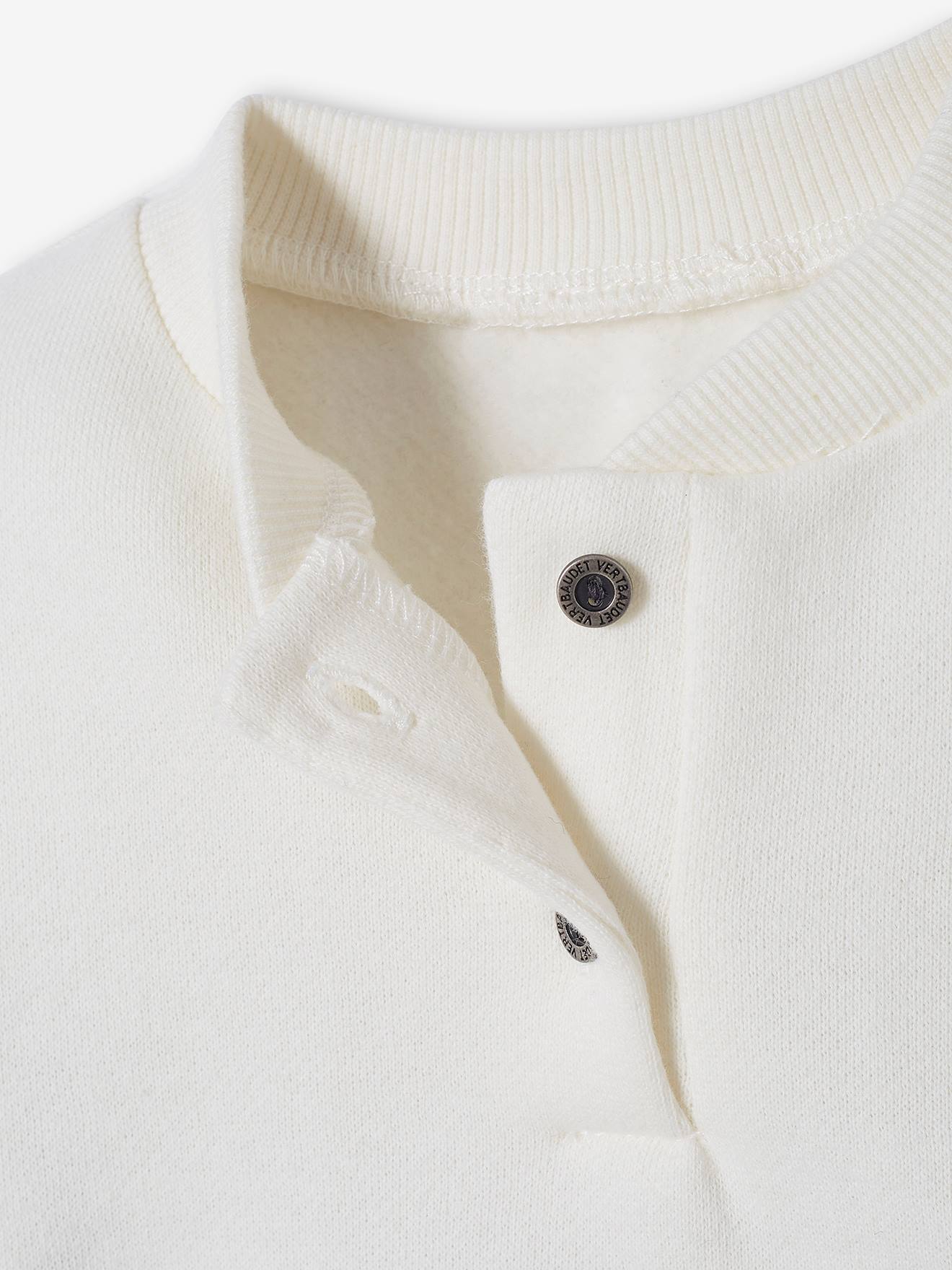O conjunto para bebê inclui um moletom de lã e calças de veludo, em branco claro liso com estampas.