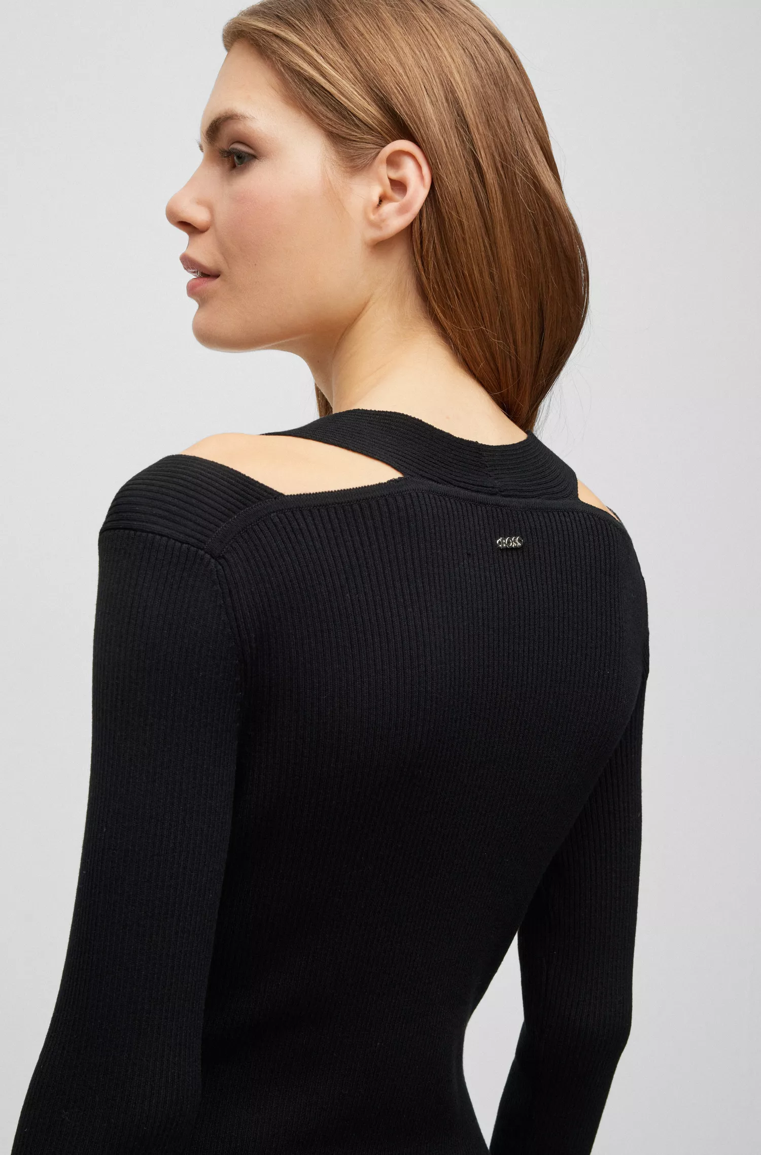 Vestido preto BOSS de manga comprida e corte justo com ombros vazados.