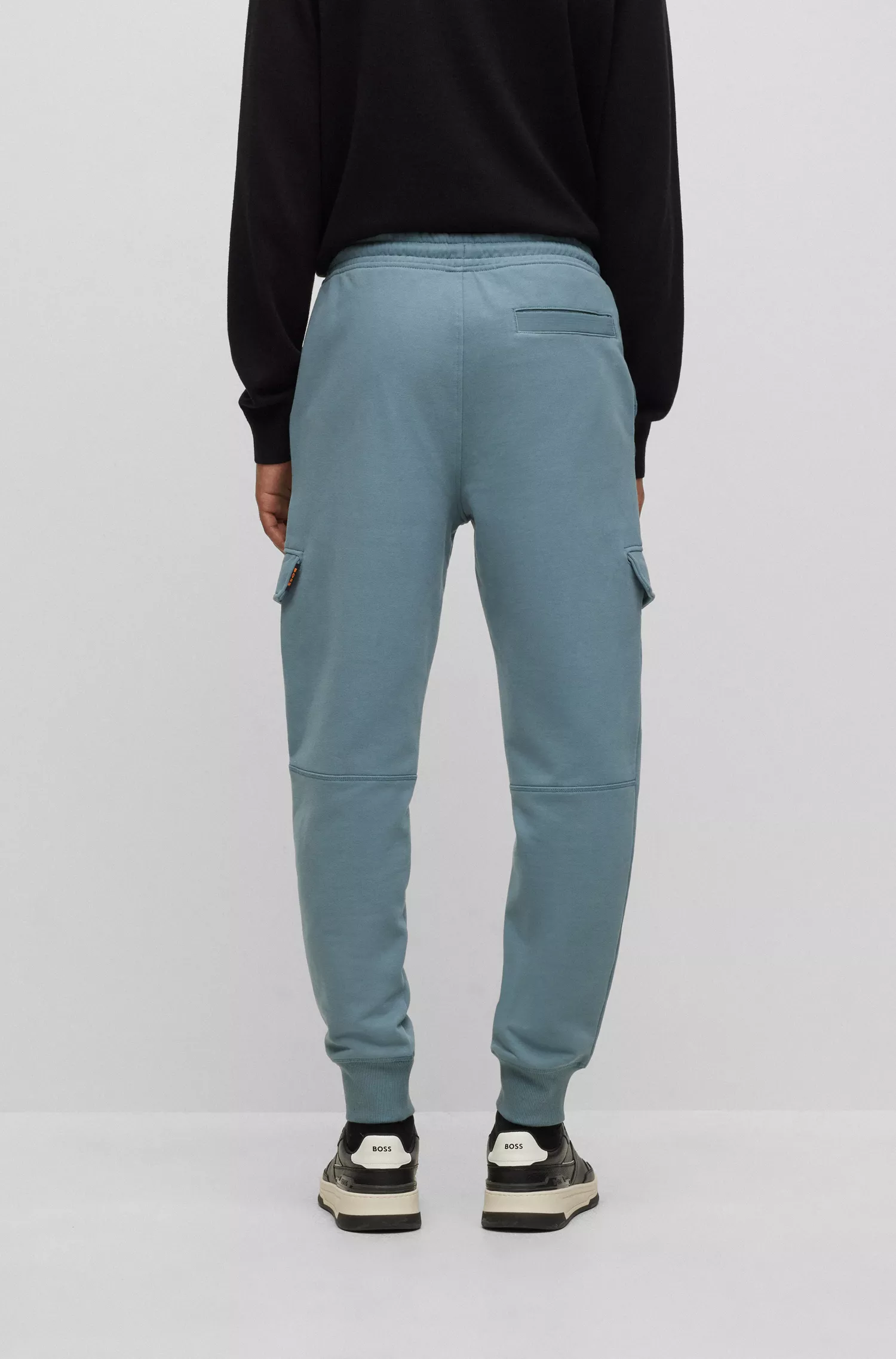 Calça de fato de treino BOSS laranja, corte regular, com bolsos cargo.