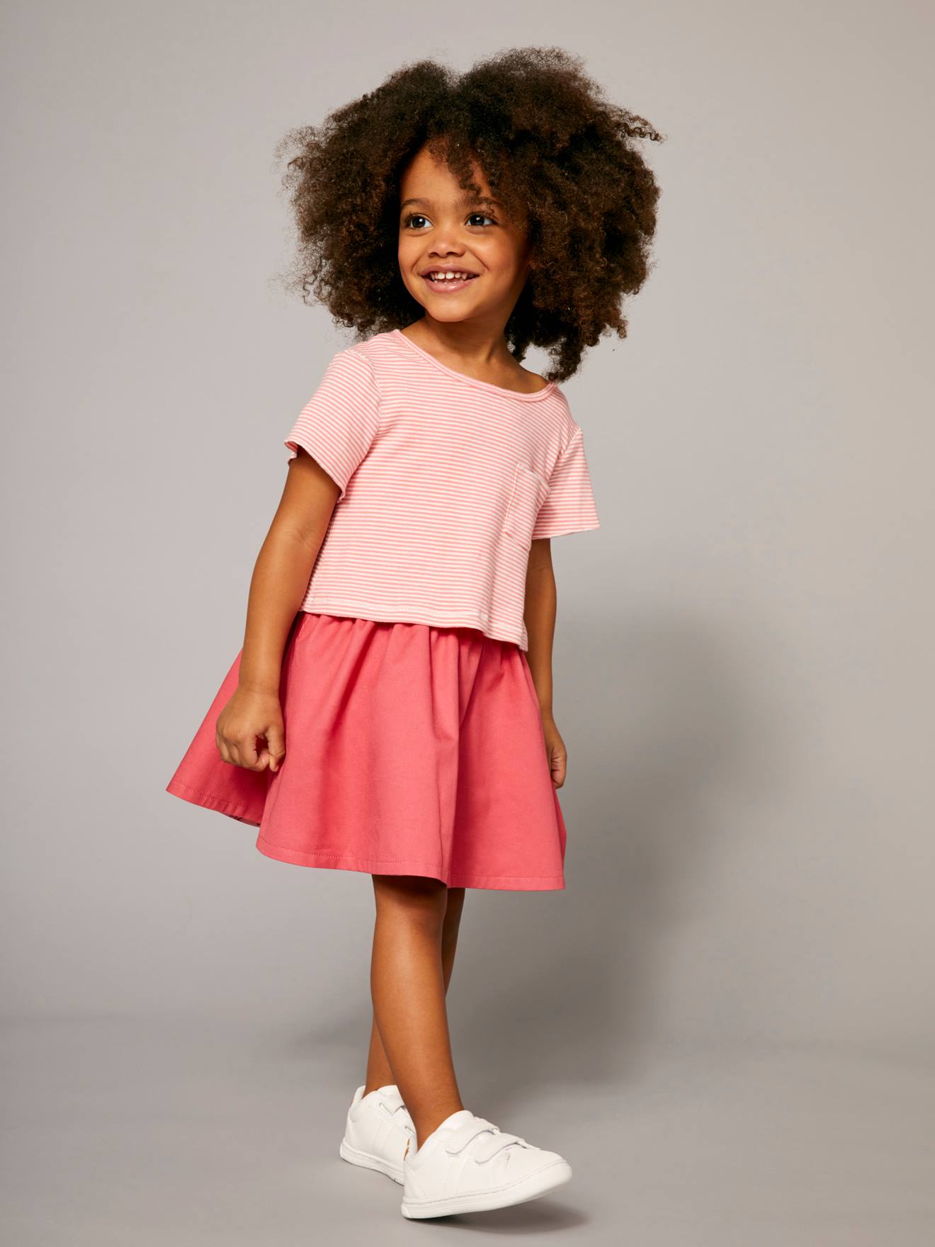 Vestido reversível para meninas em dois tecidos estampados rosa claro.