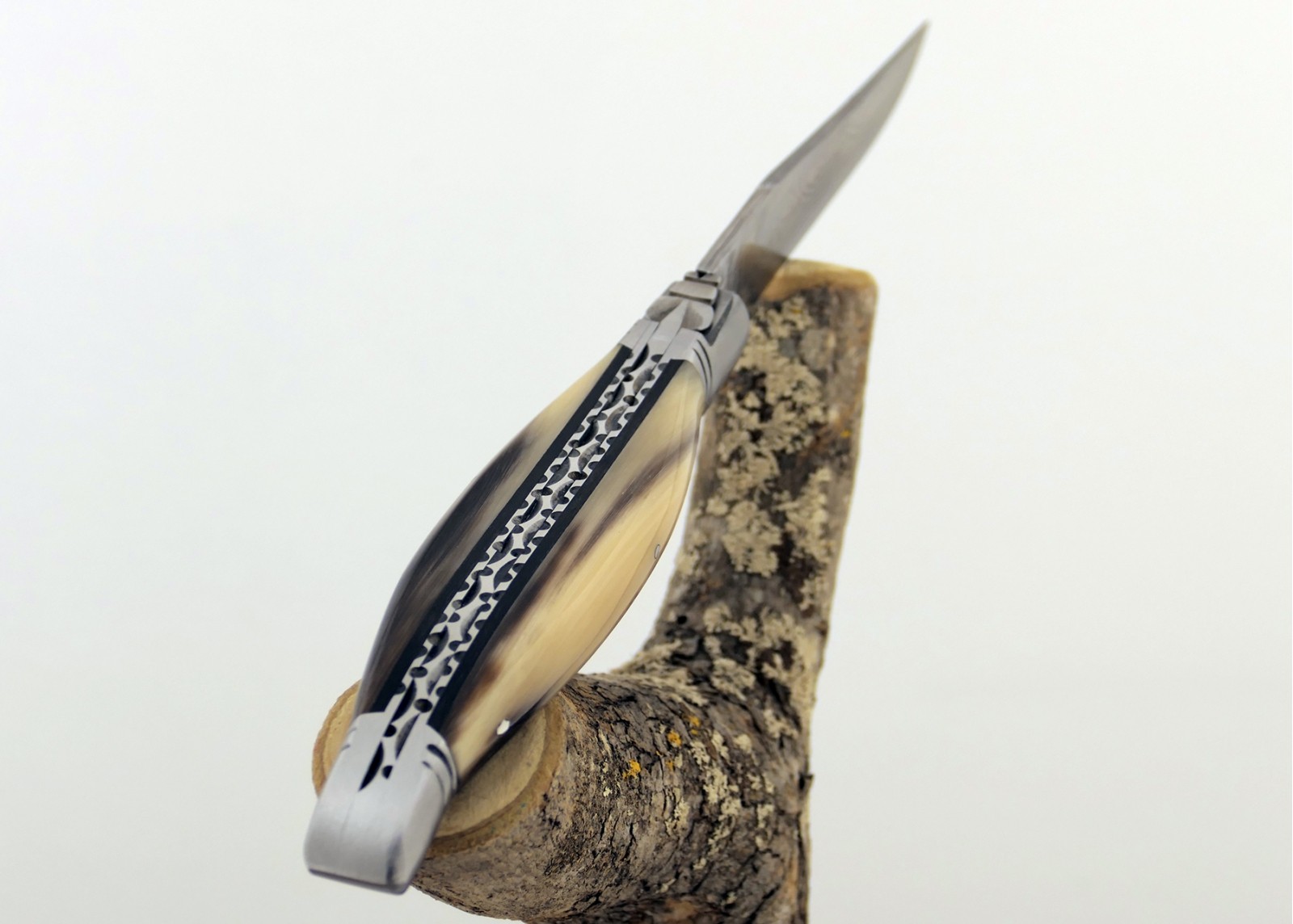 Couteau Laguiole prestige avec un manche en pointe de corne blonde et mitres en acier inoxydable et lame Damas