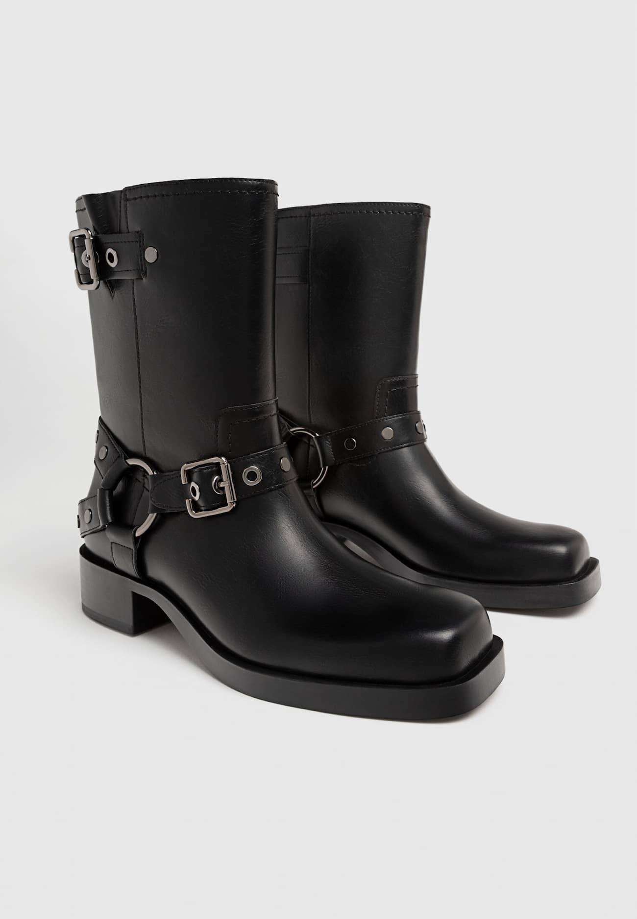 Botas de cano curto estilo motociclista, sem salto, com detalhes de fivela.