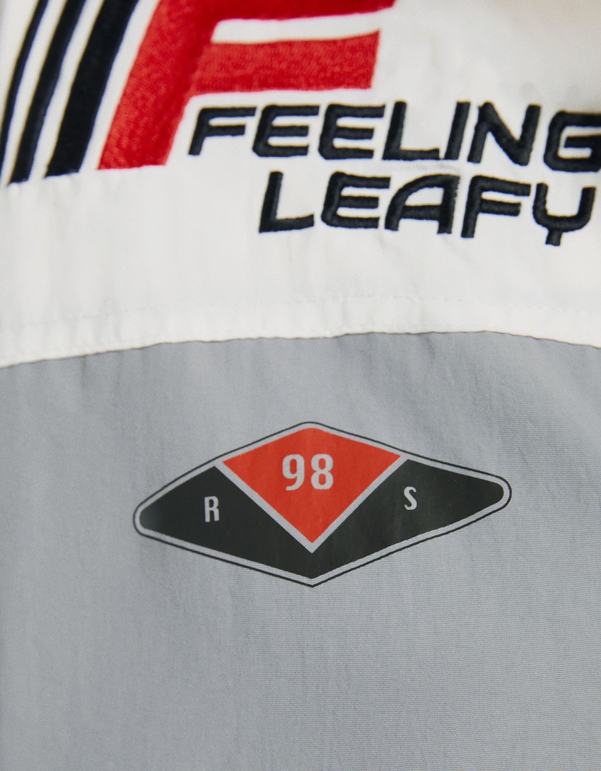 Jaqueta de nylon com capuz e patches.