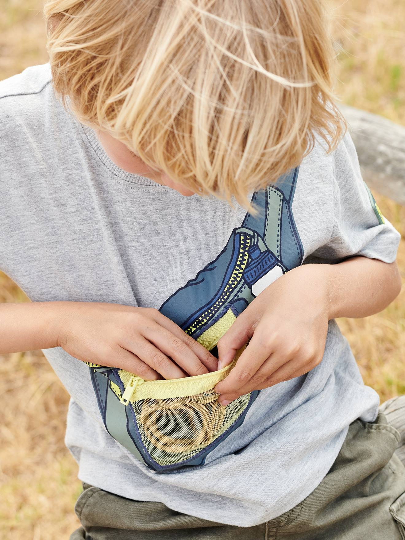 Camiseta infantil masculina com estampa de pochete, efeito ótico e bolso com zíper, na cor cinza mescla.