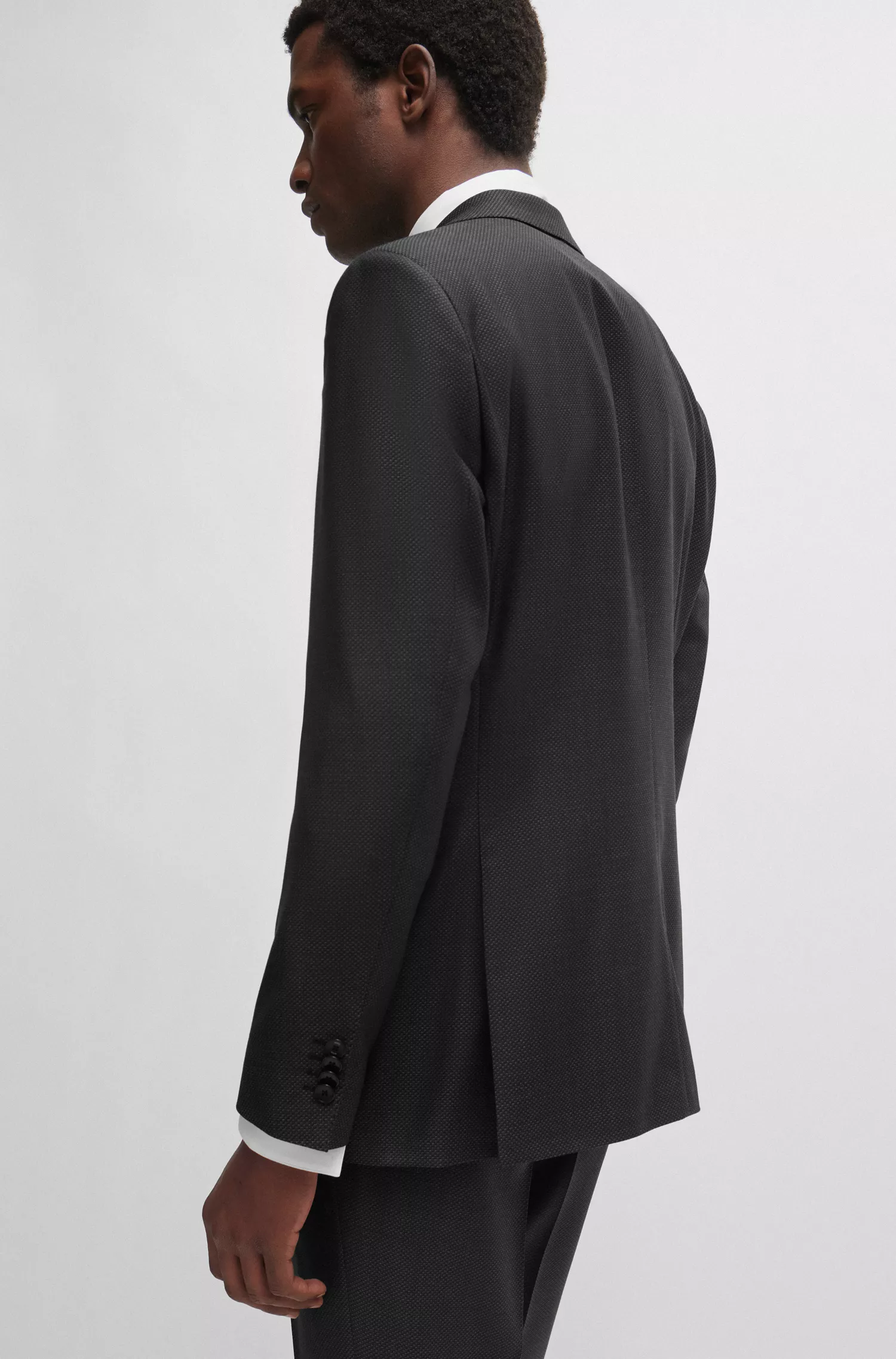 Terno BOSS preto, corte regular, em lã virgem com microestampa.