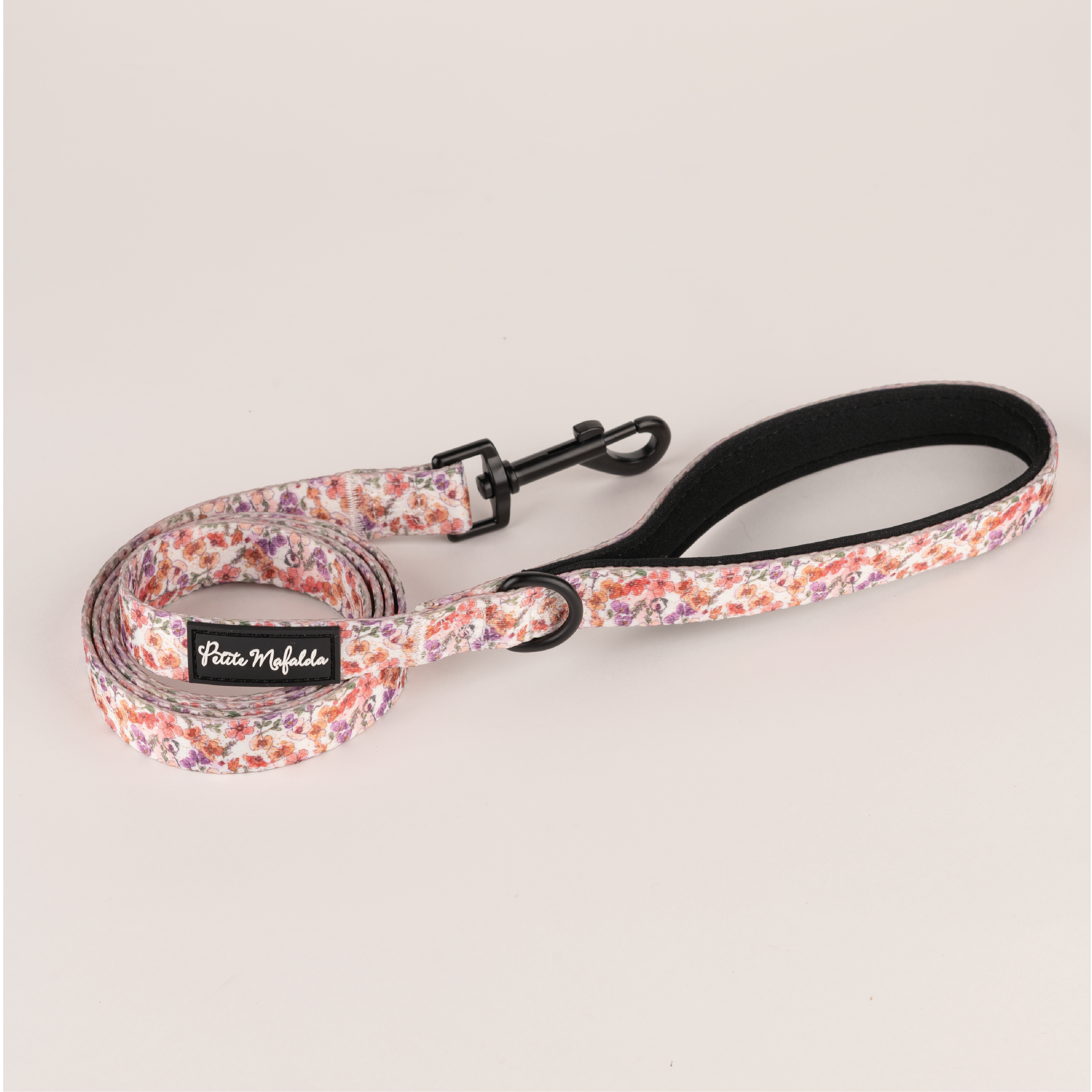 Conjunto Petite Mafalda com coleira, guia e porta-bolsas com estampa floral rosa para cães.