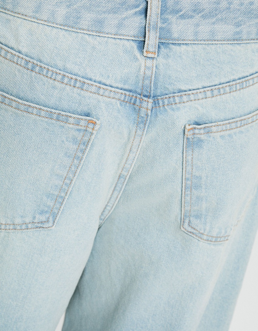 Calça jeans de corte amplo com abertura lateral