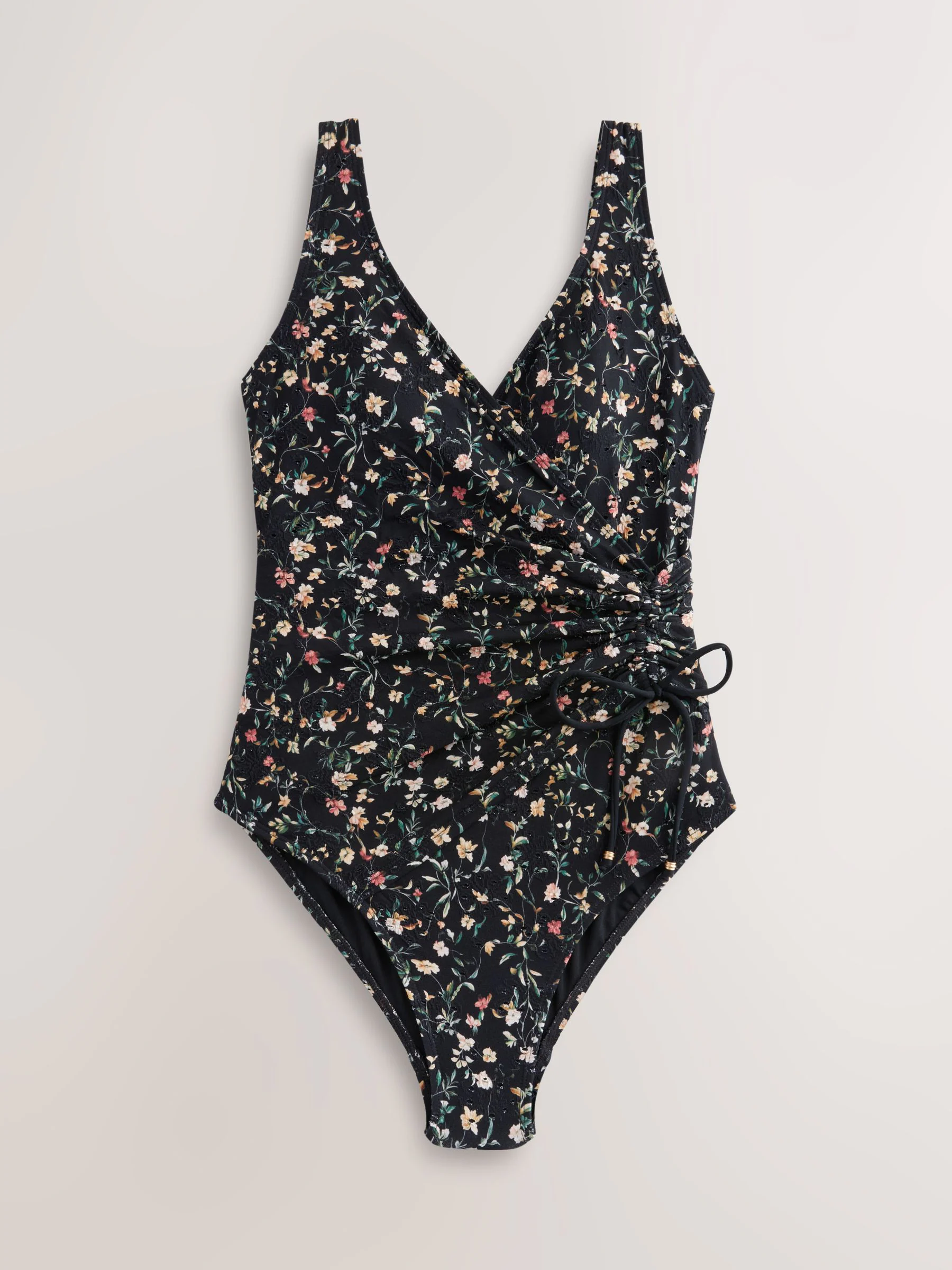 Zwart met broderie en fijne print - Badpak met vormgevende zijrimpeling en buikcorrectie