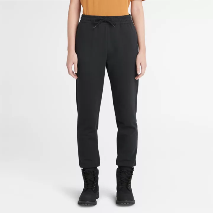 Calça de fato de treino feminina preta com bordado de árvore.