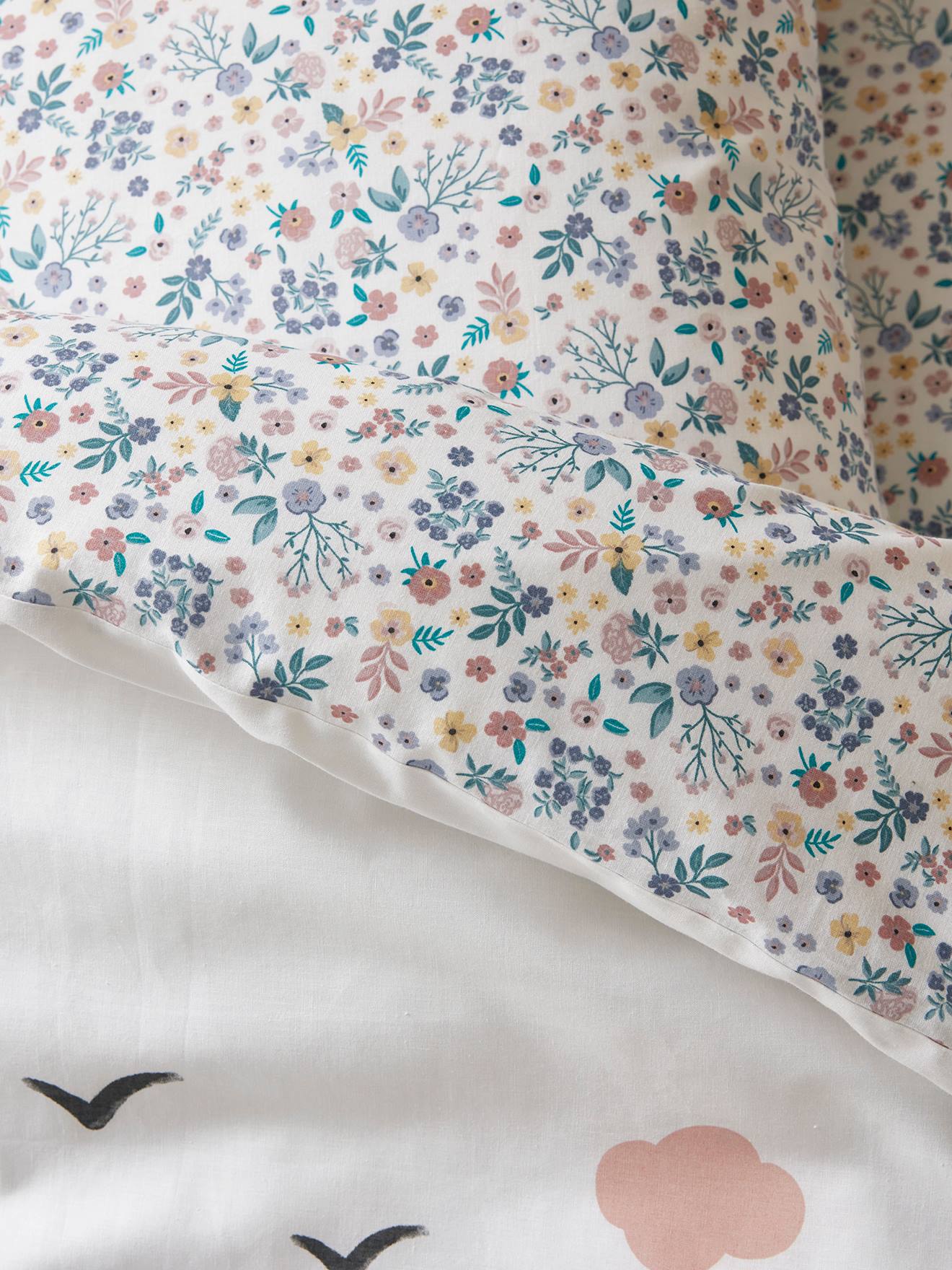Conjunto infantil de capa de edredom e fronha, liso em branco claro e lilás com estampas.