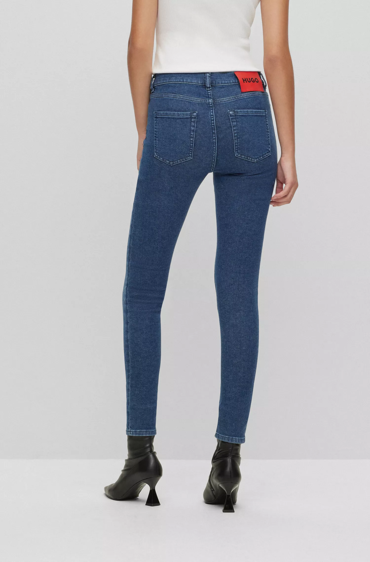 Calça jeans HUGO vermelha, extra slim fit, em denim elástico azul.