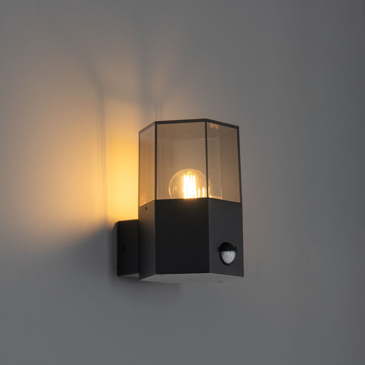 Buiten wandlamp zwart met smoke glas zeshoek en bewegingssensor - Denmark