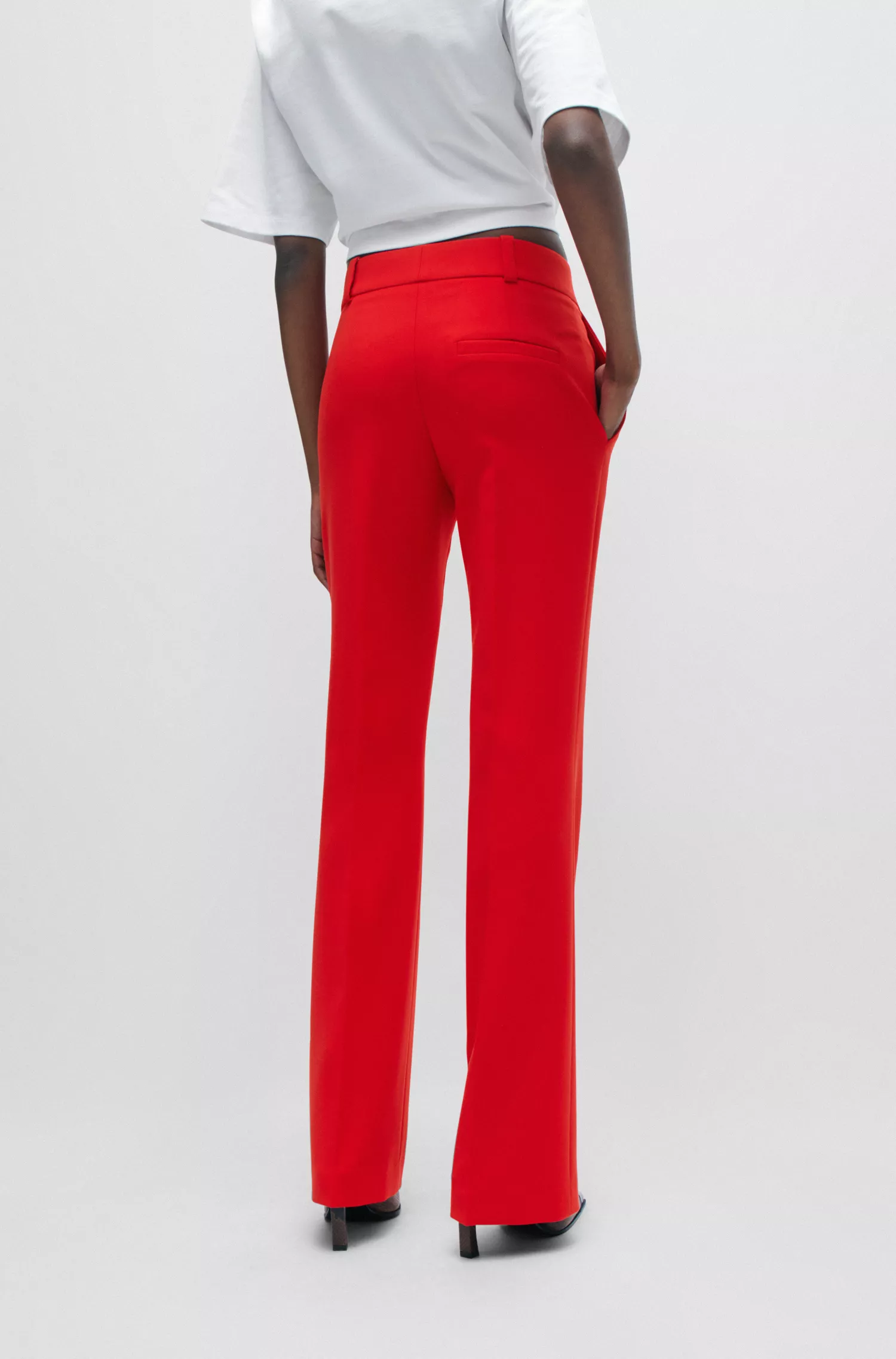 Calça HUGO vermelha, corte reto, estilo bota, em tecido elástico.