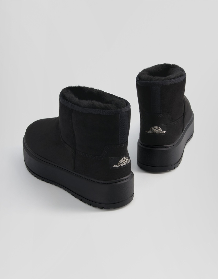 Botas de cano curto com plataforma e forro de pele sintética.